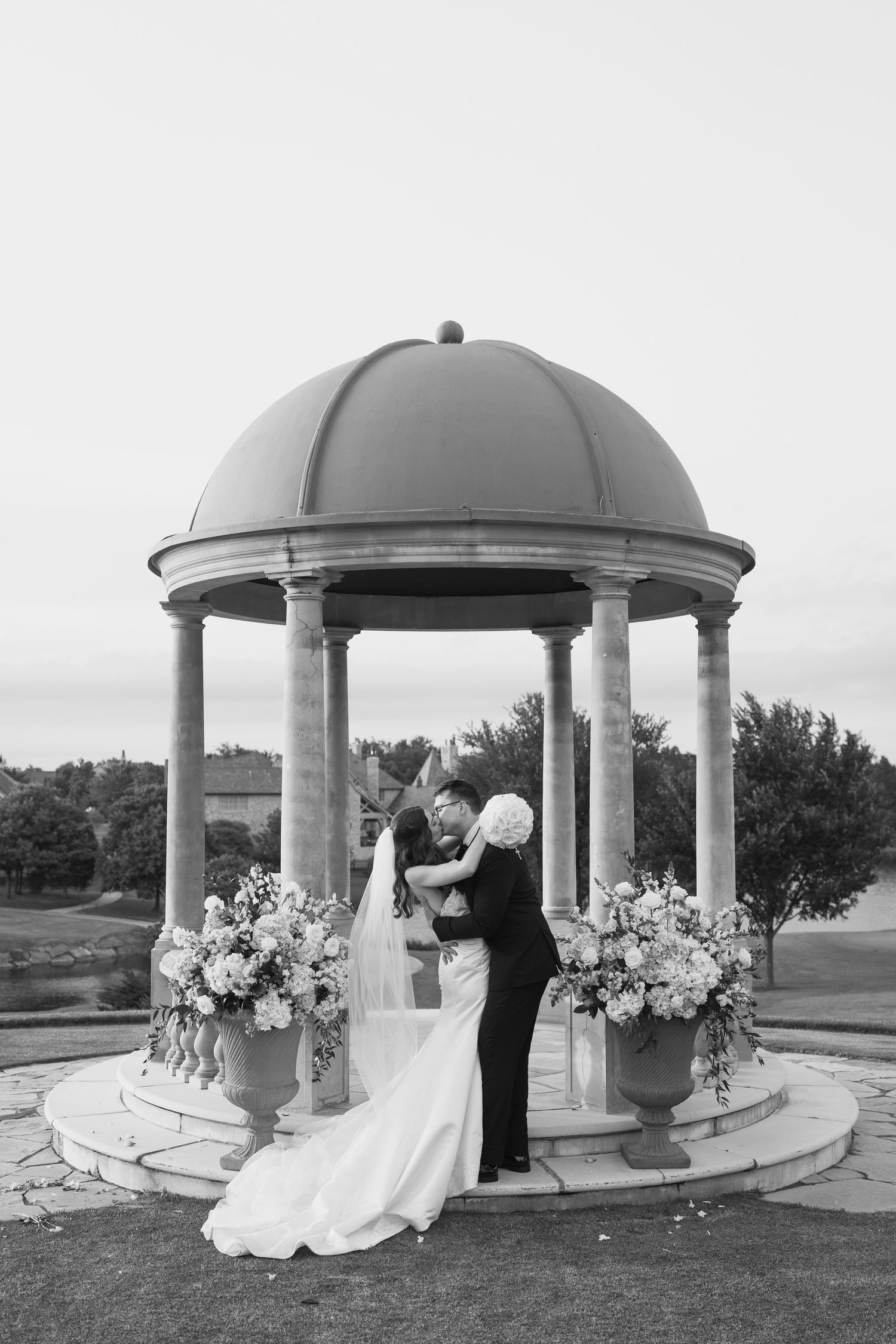 Series of romantic moments captured under an ornate stone gazebo with floral arrangements.