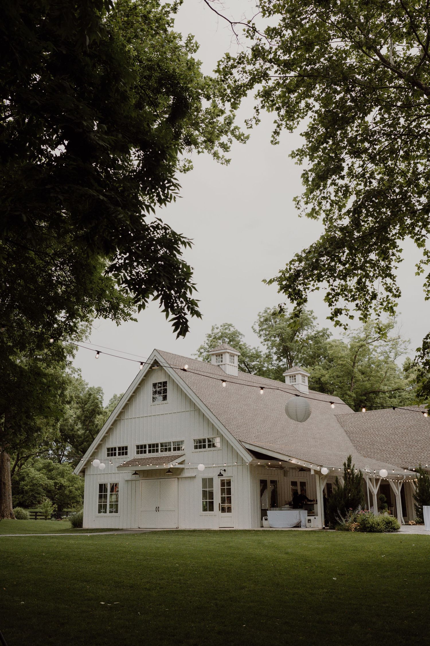 Classic white barn wedding venue with architectural details and lush landscaping.