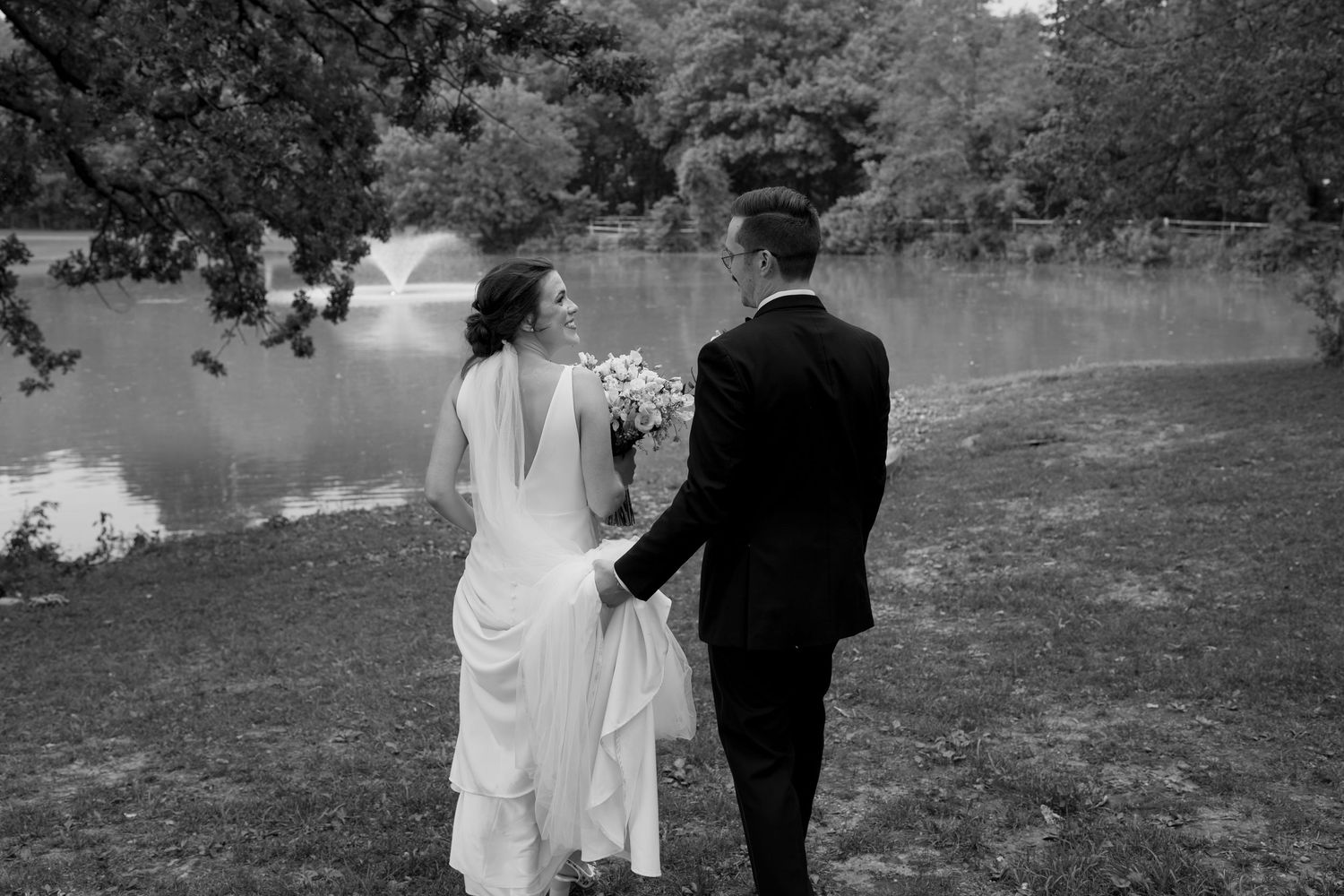 Black and white wedding portrait series showing a couple walking through a scenic outdoor venue.