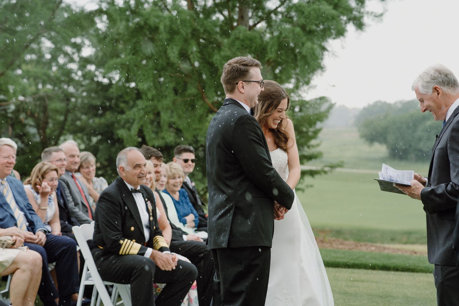 A row of outdoor wedding ceremony photos showing guests seated in chairs on a green lawn during a cloudy day.