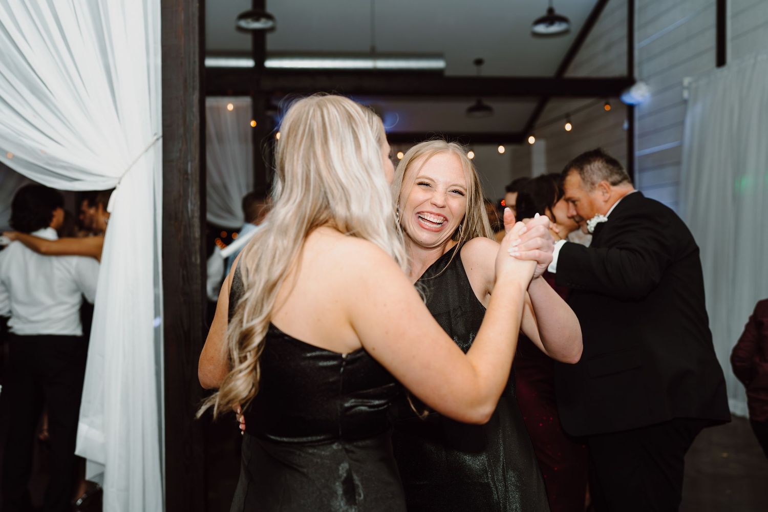 Wedding guests share a joyful dance moment at the reception.