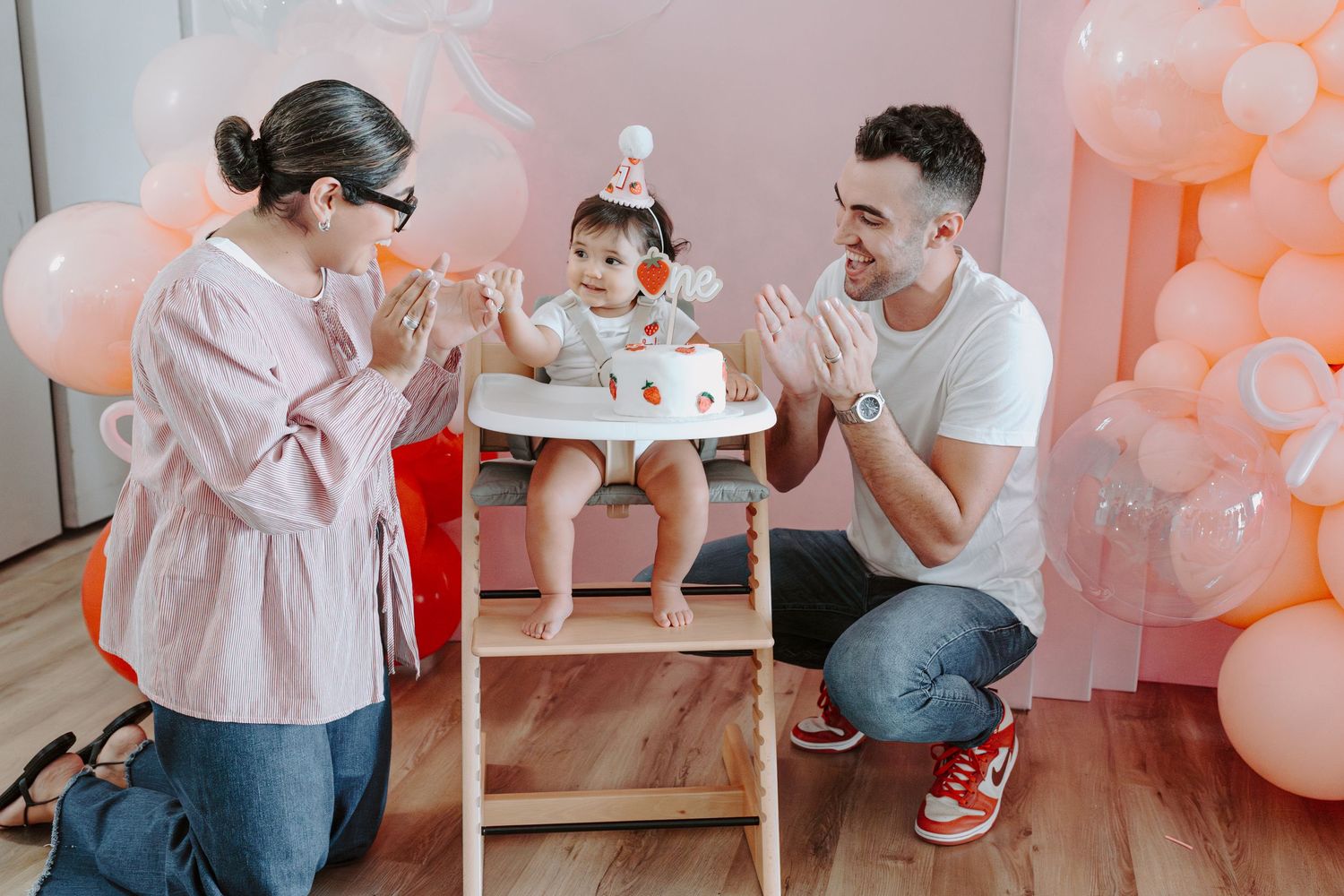 Birthday celebration setup with pink balloons and decorative backdrop.