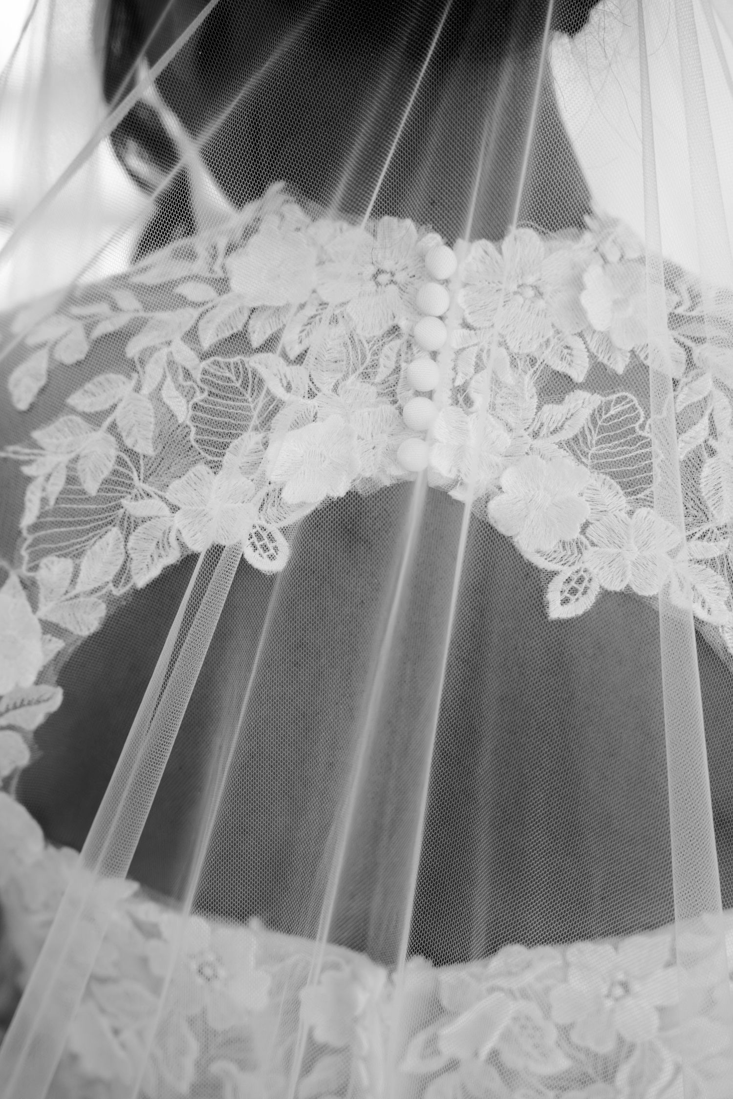 Close-up detail of delicate lace trim on a white wedding veil.