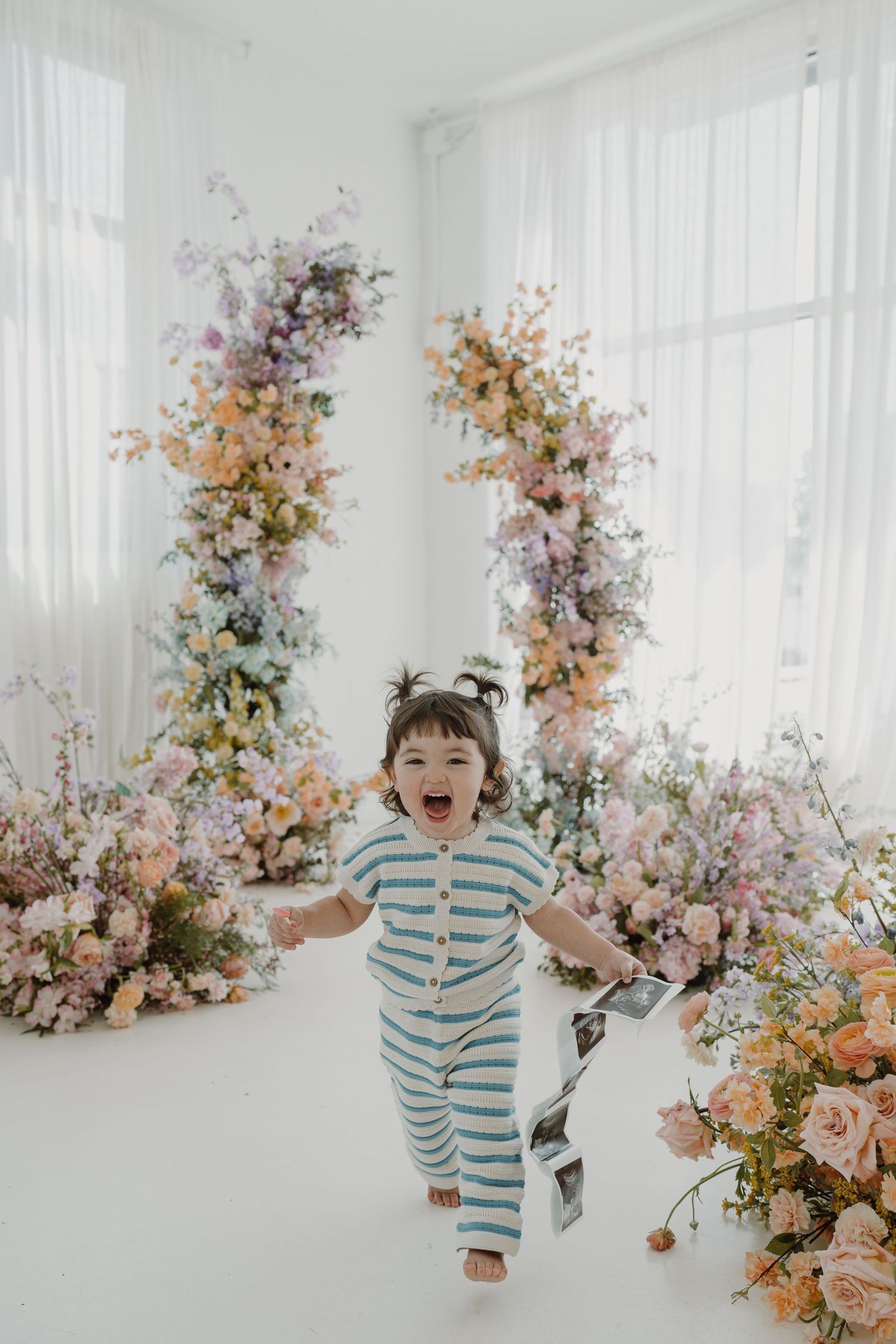 Energetic movement captured in bright studio setting with pastel flower arrangements.
