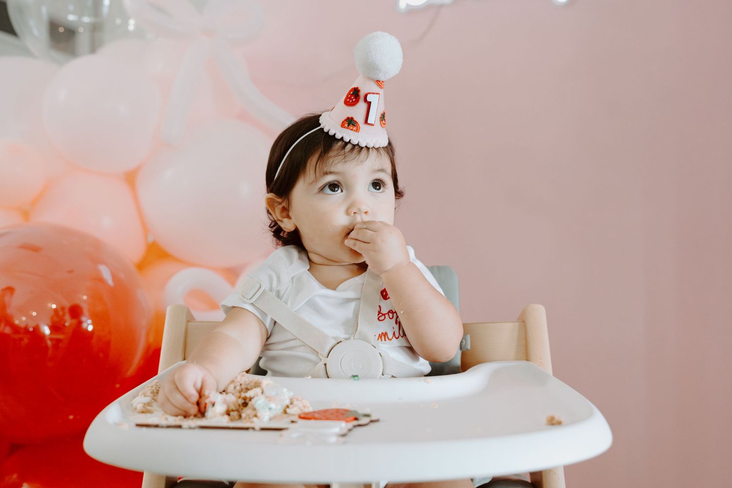 Pink-themed birthday setup with balloons and decorative lighting.