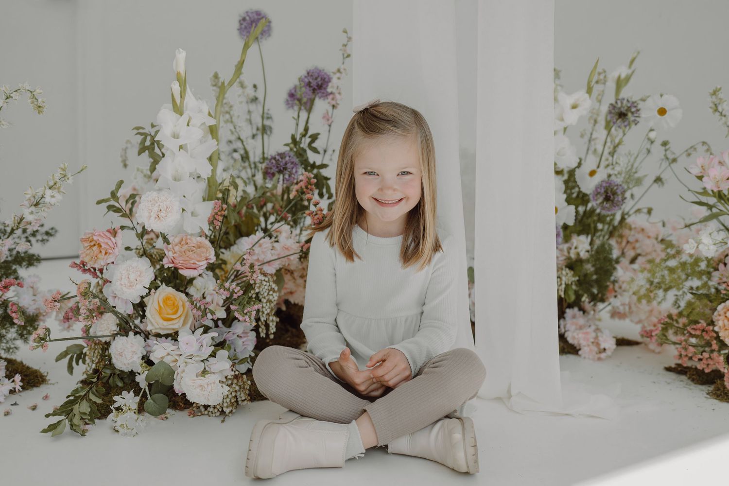 Soft portrait with delicate flower arrangements featuring roses and wildflowers in natural light.