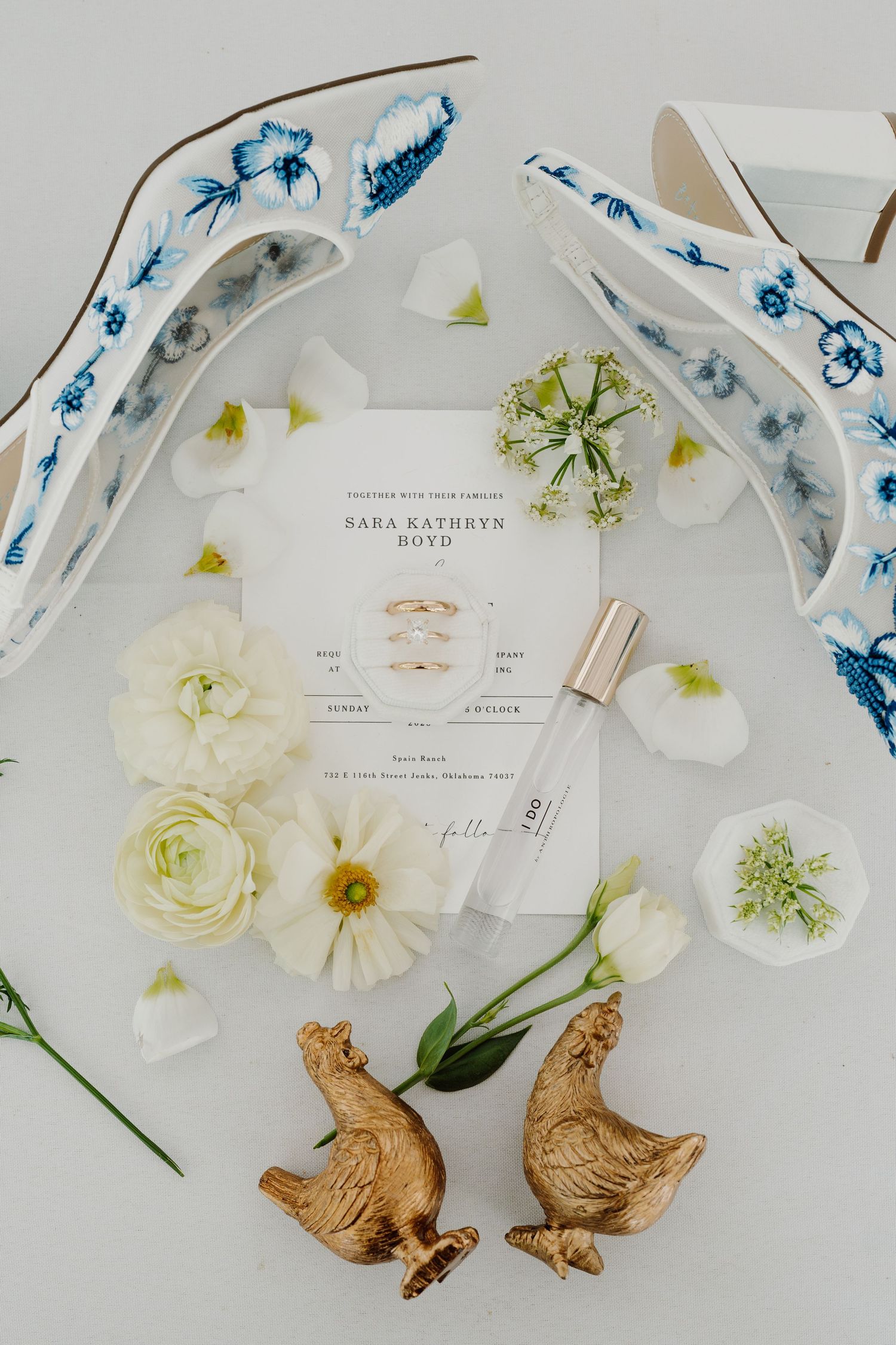 Wedding invitation details with delicate white flowers and decorative blue accents on a light background.