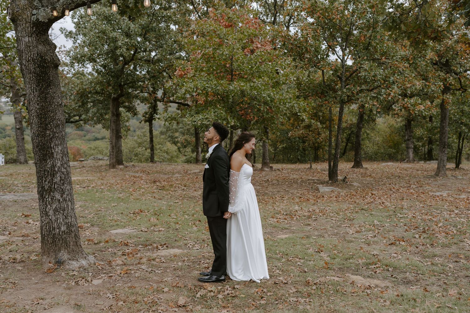 A couple shares a tender moment during their outdoor autumn wedding.