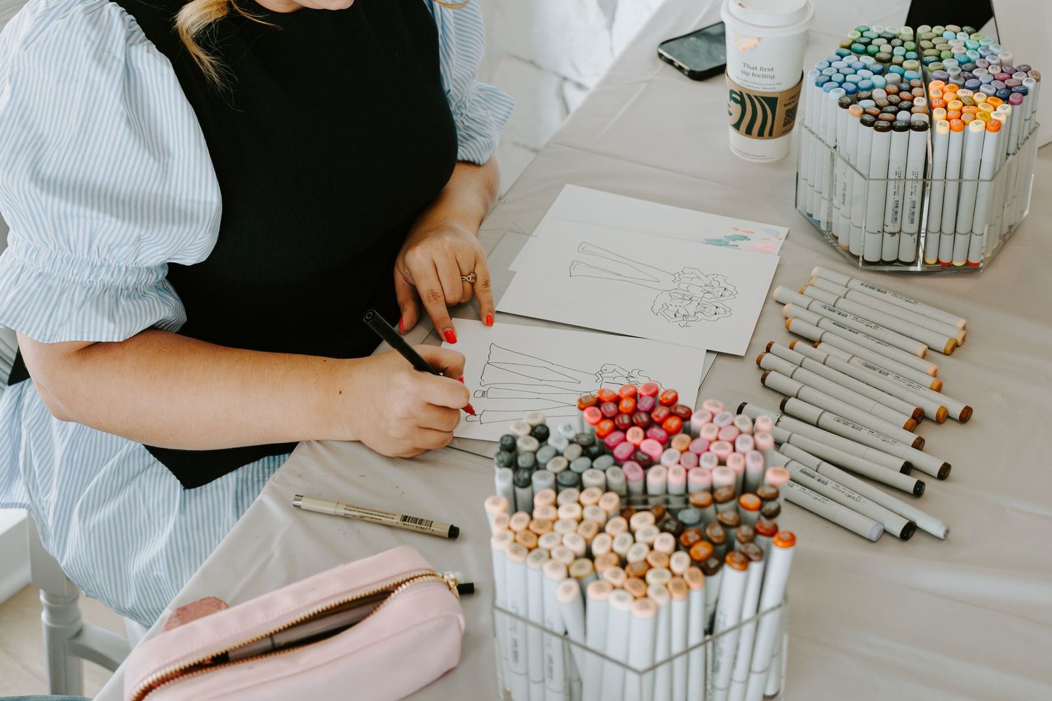 Art supplies and markers arranged neatly on a white surface for a creative project.