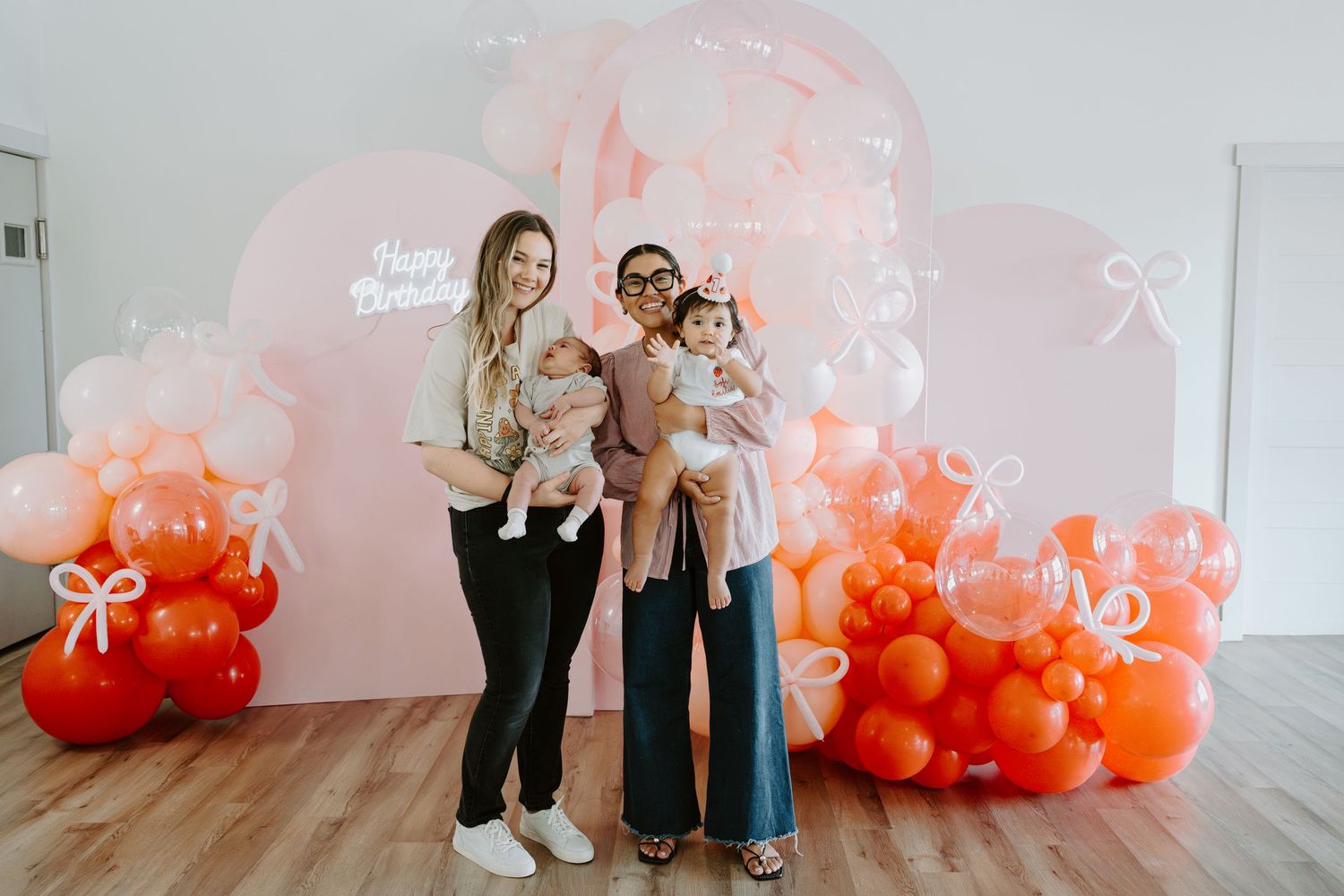 Studio photography setup featuring an elegant balloon display in peach and orange hues.