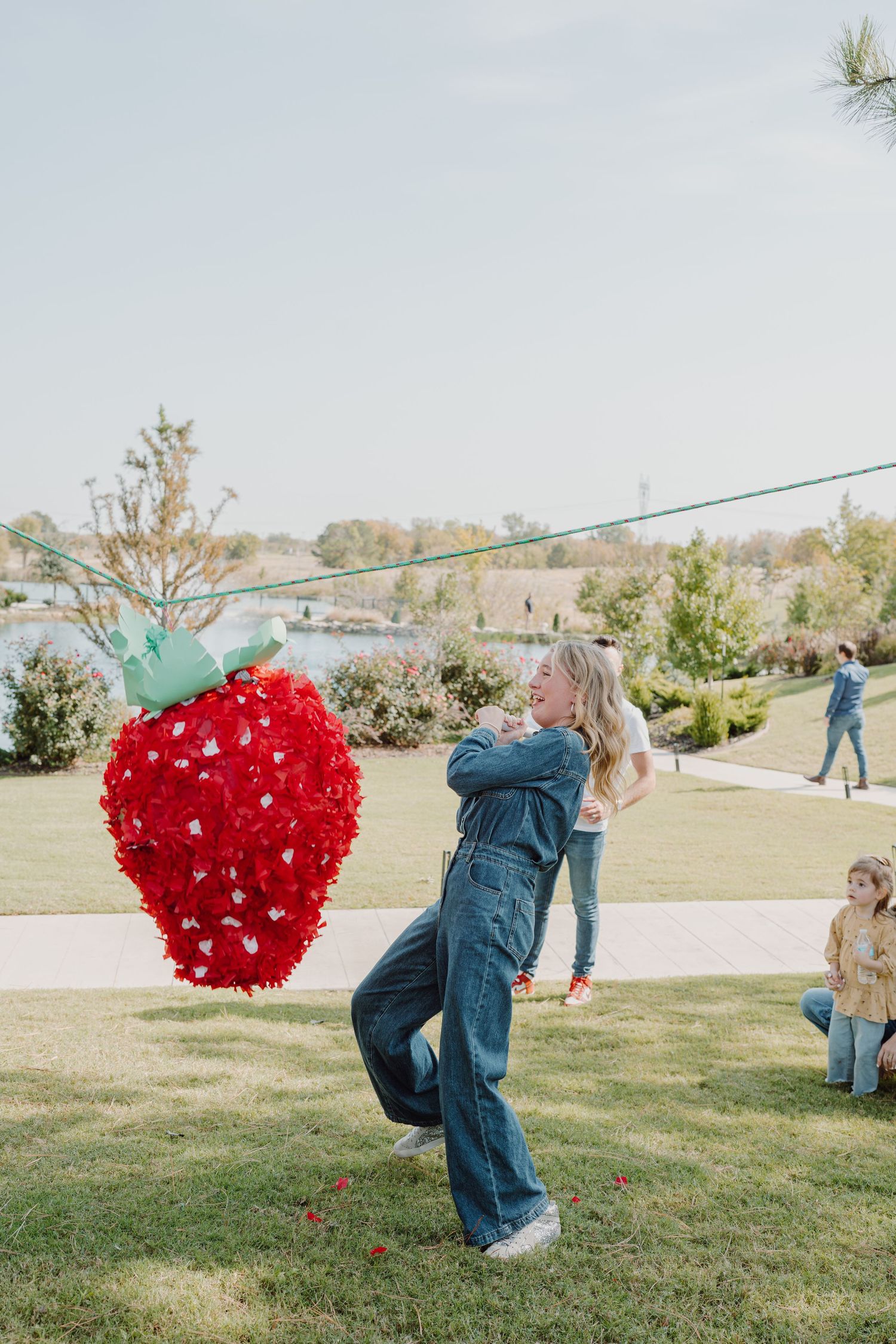 A red heart piñata swings through the air during an outdoor event.