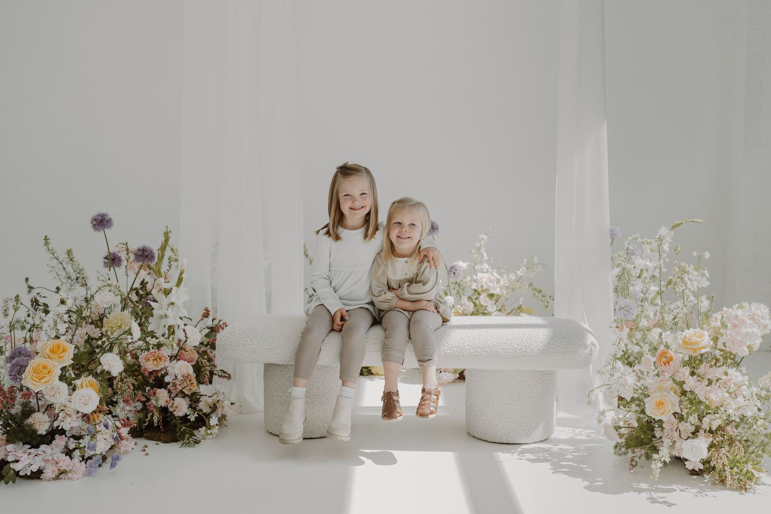 Minimalist white interior with carefully arranged ceramics and floral displays creating a serene atmosphere.