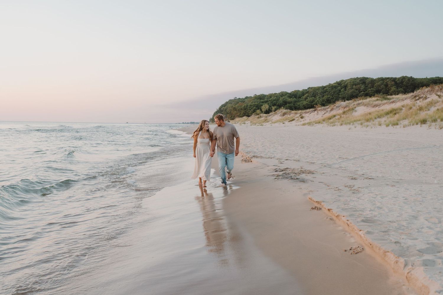 Romantic beach stroll with footprints in the sand during golden hour.