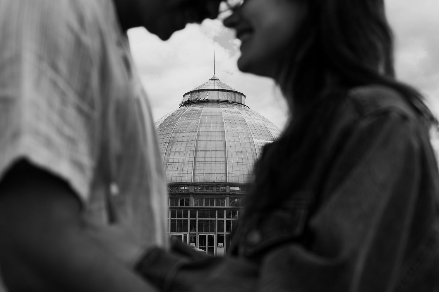 Silhouettes against a conservatory building in black and white photography.