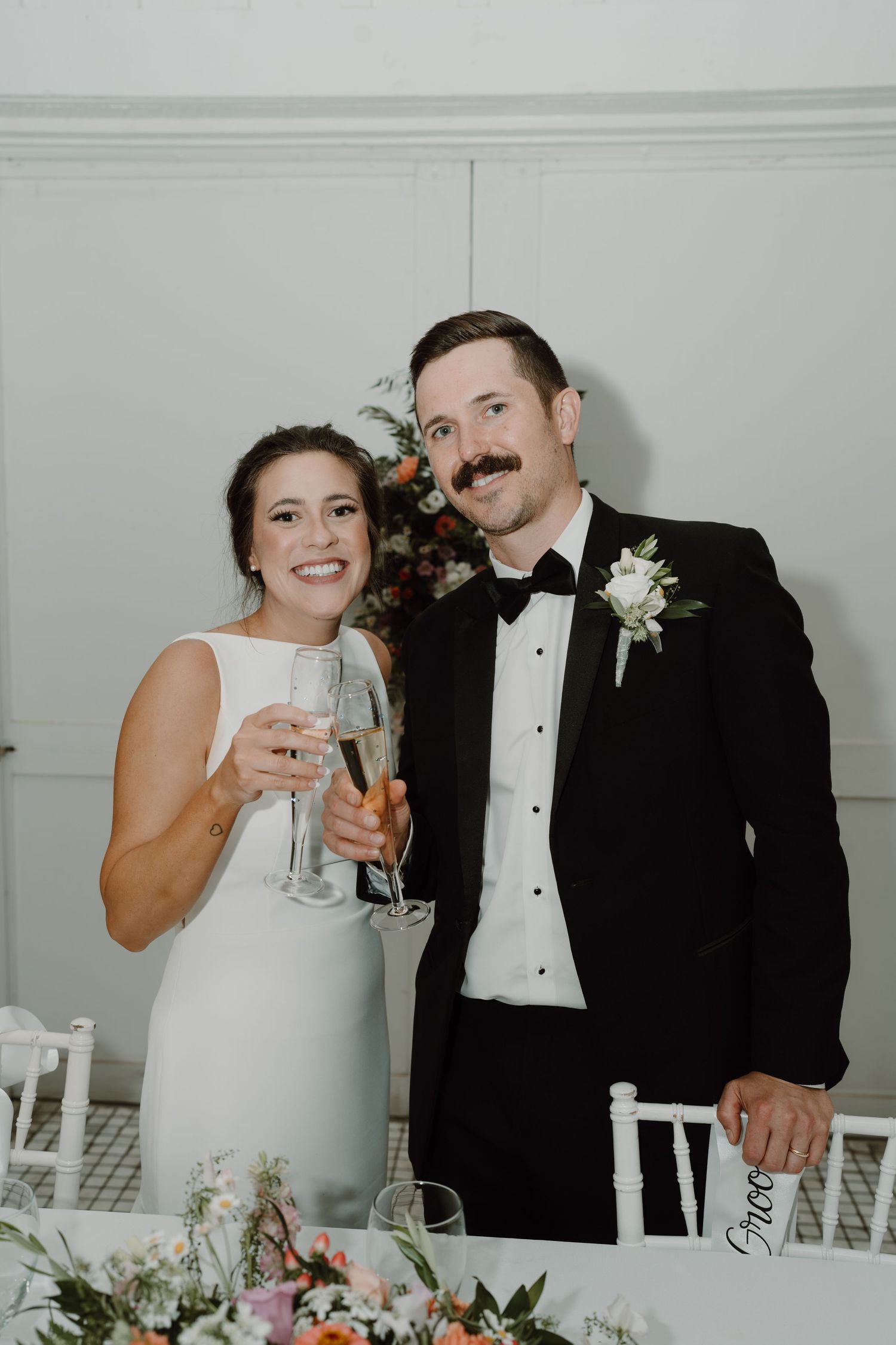 Newlyweds toasting with champagne glasses at their wedding reception.