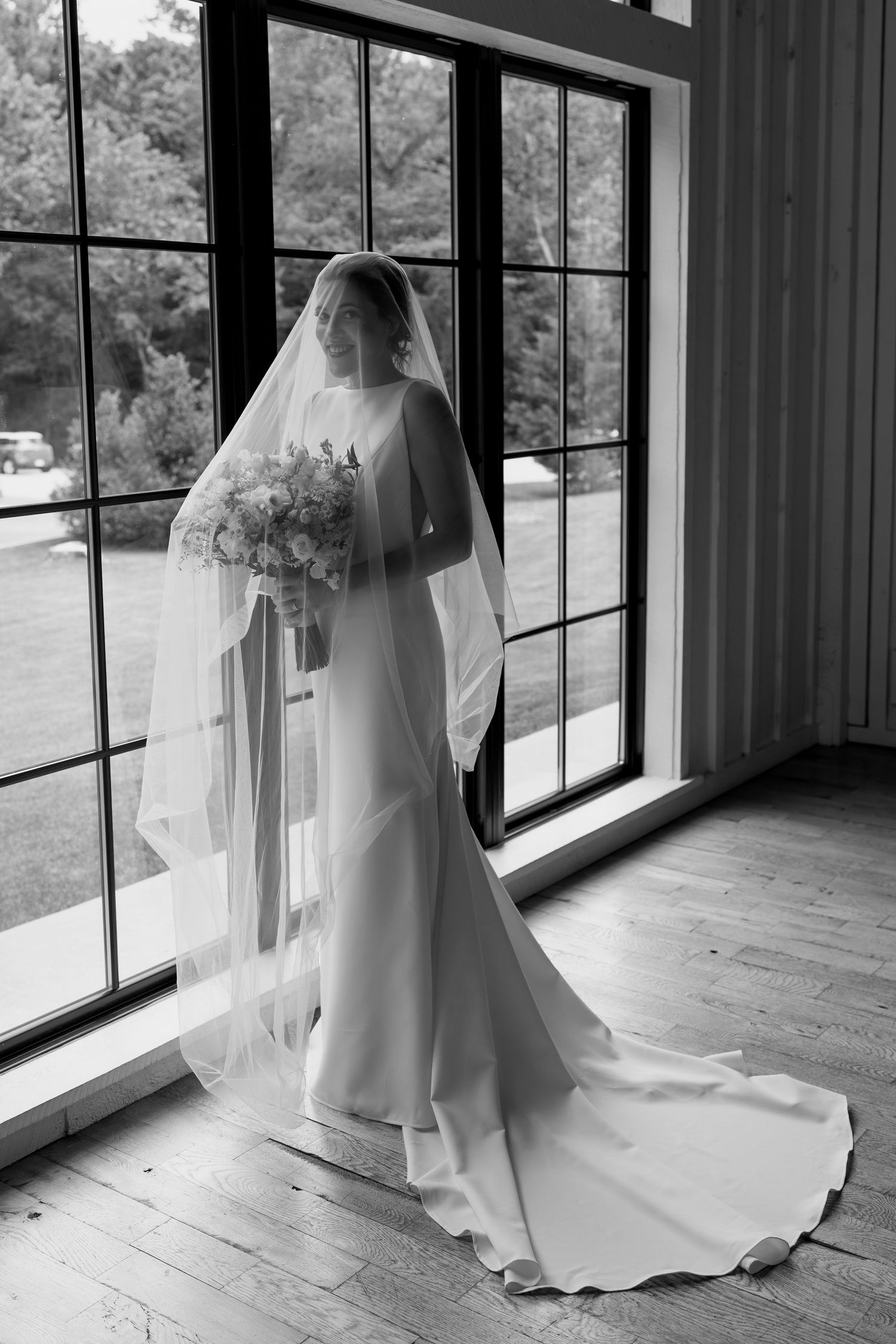 Series of shots showing a bride in classic white gown with cathedral veil by windows.