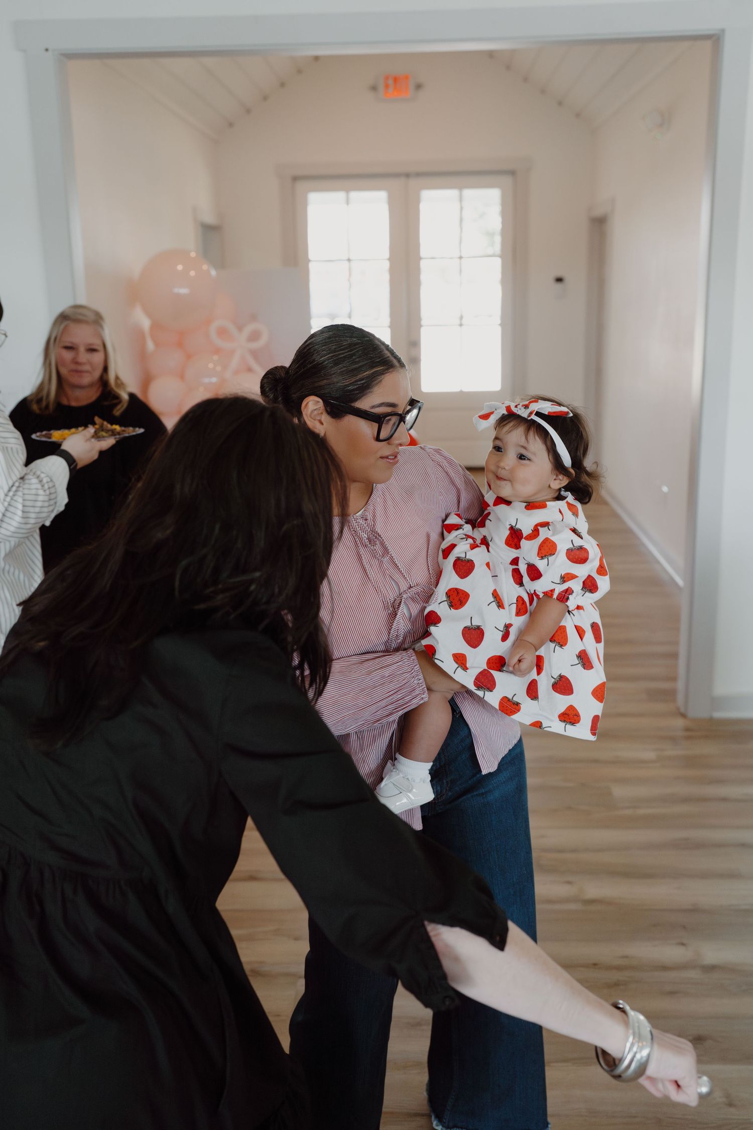 People interacting in a bright white room with heart-themed decorations.