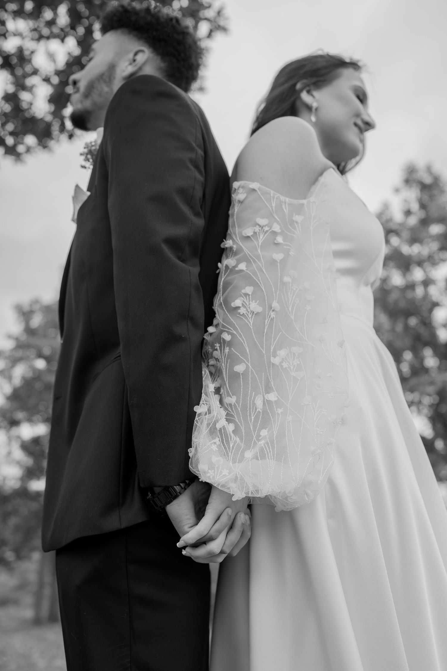 Black and white photo of newlyweds sharing an intimate moment outdoors.