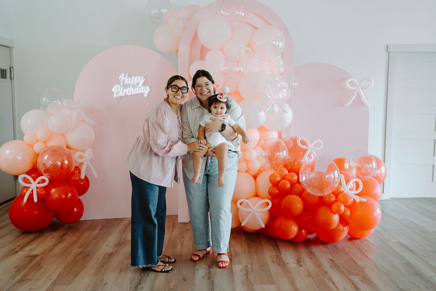 Modern studio photography setup with ombre balloon installation from pink to orange.
