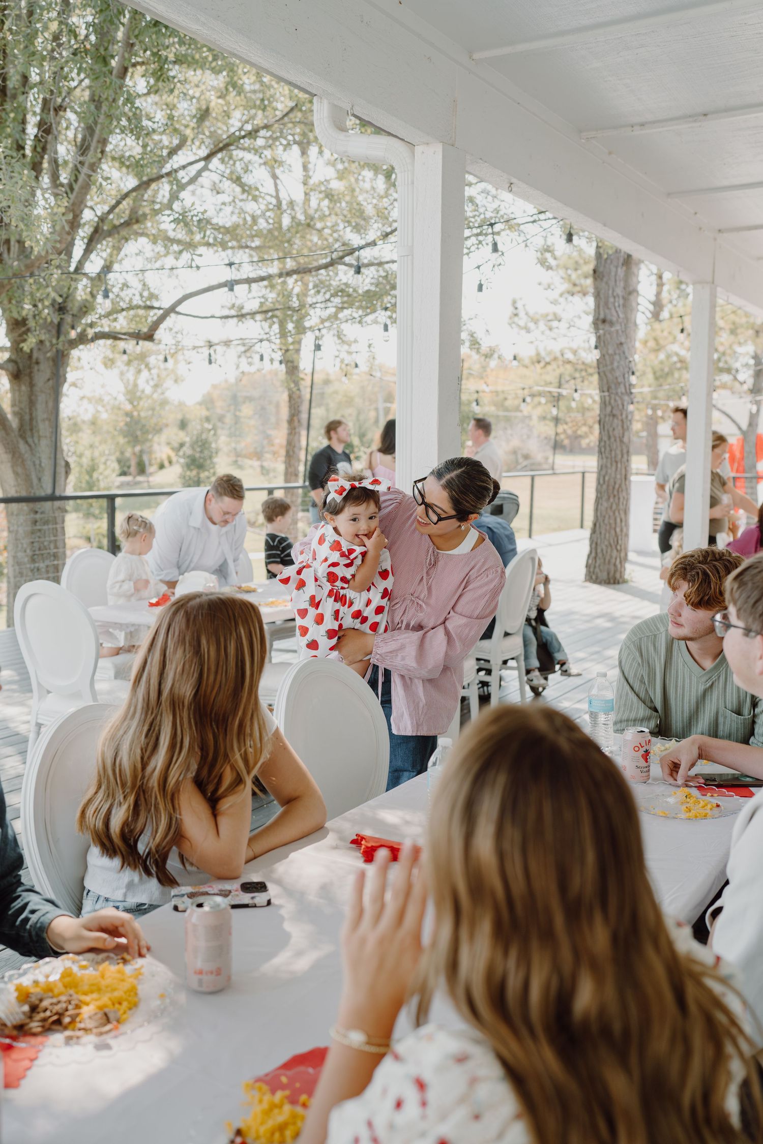 Wedding reception guests enjoying a meal at outdoor covered pavilion.
