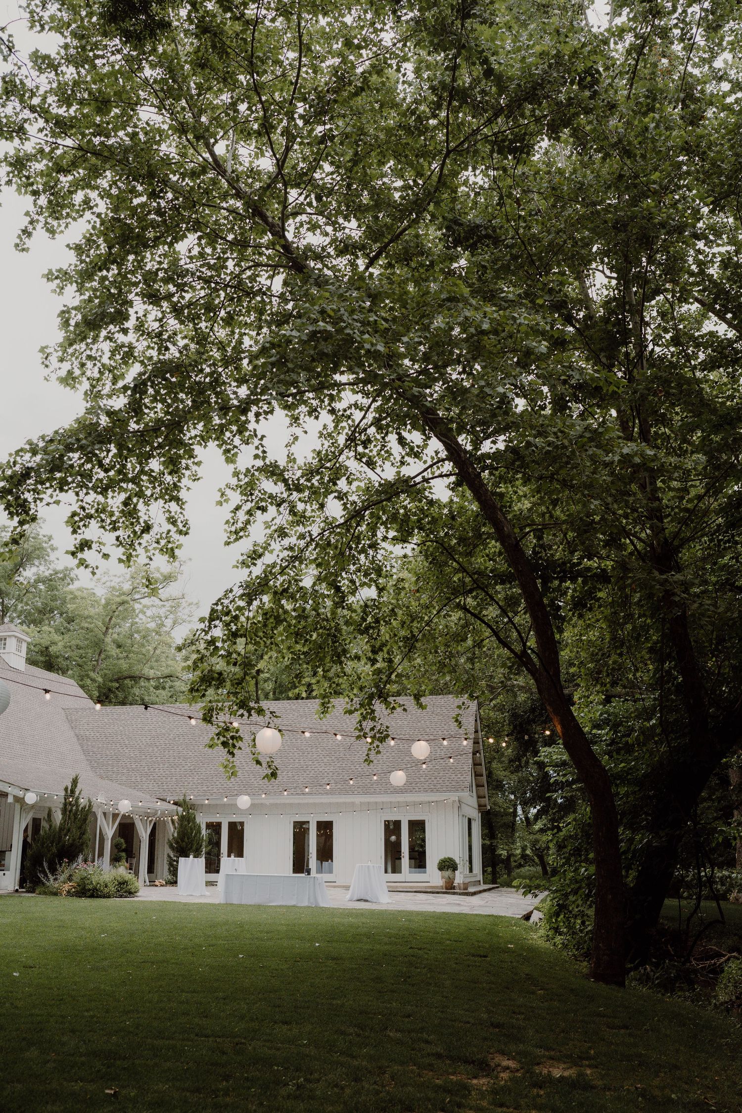 White colonial-style venue building with large windows and trees visible in the background.