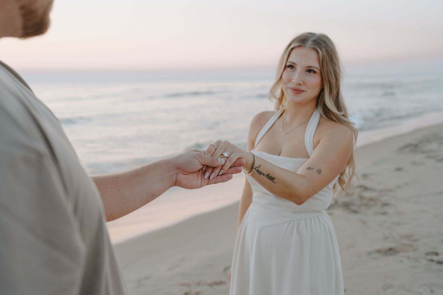 Couple sharing romantic moments during beach engagement photoshoot.