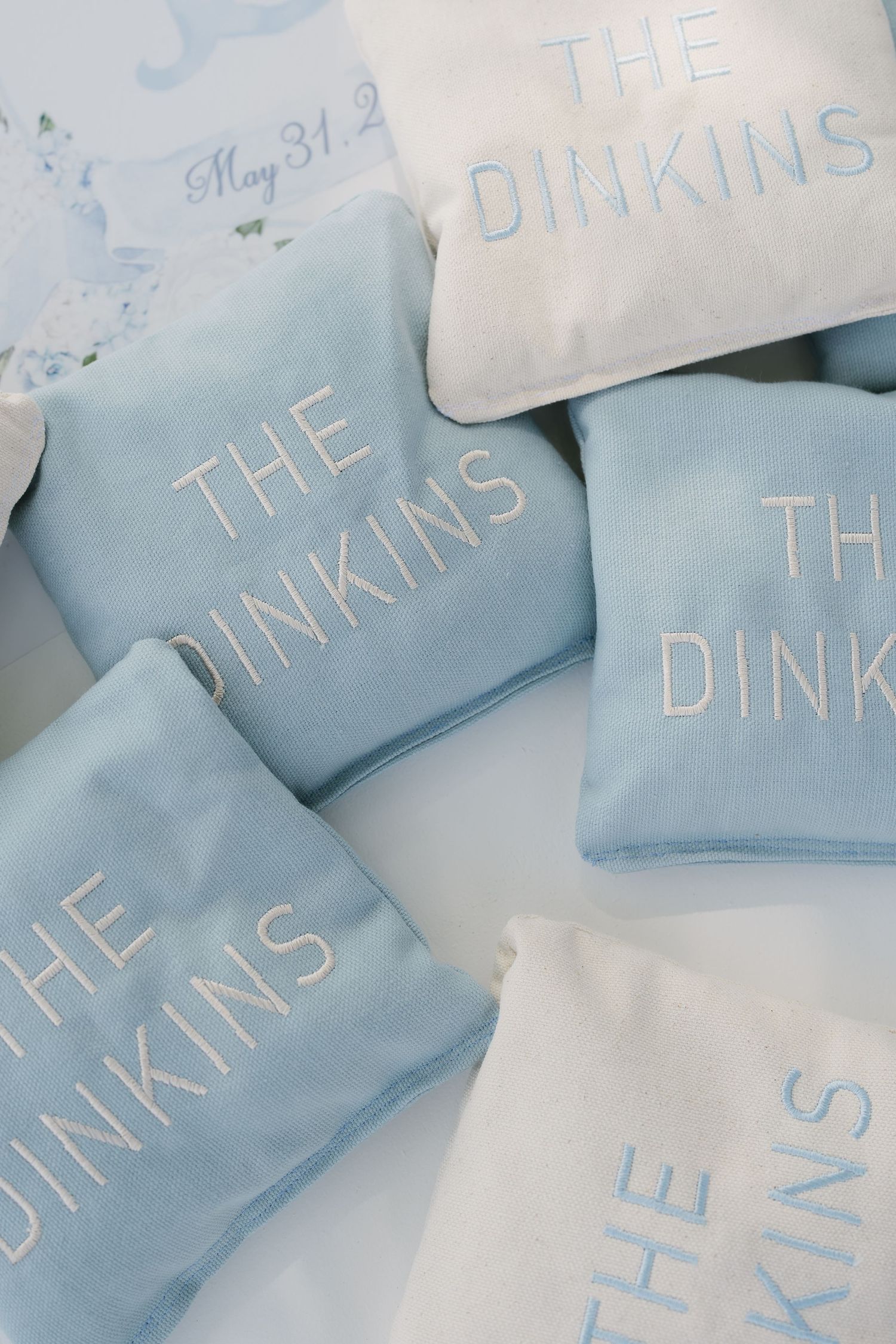 Blue and white embroidered throw pillows reading THE DINKINS, perfect for a personalized wedding gift or home decor.