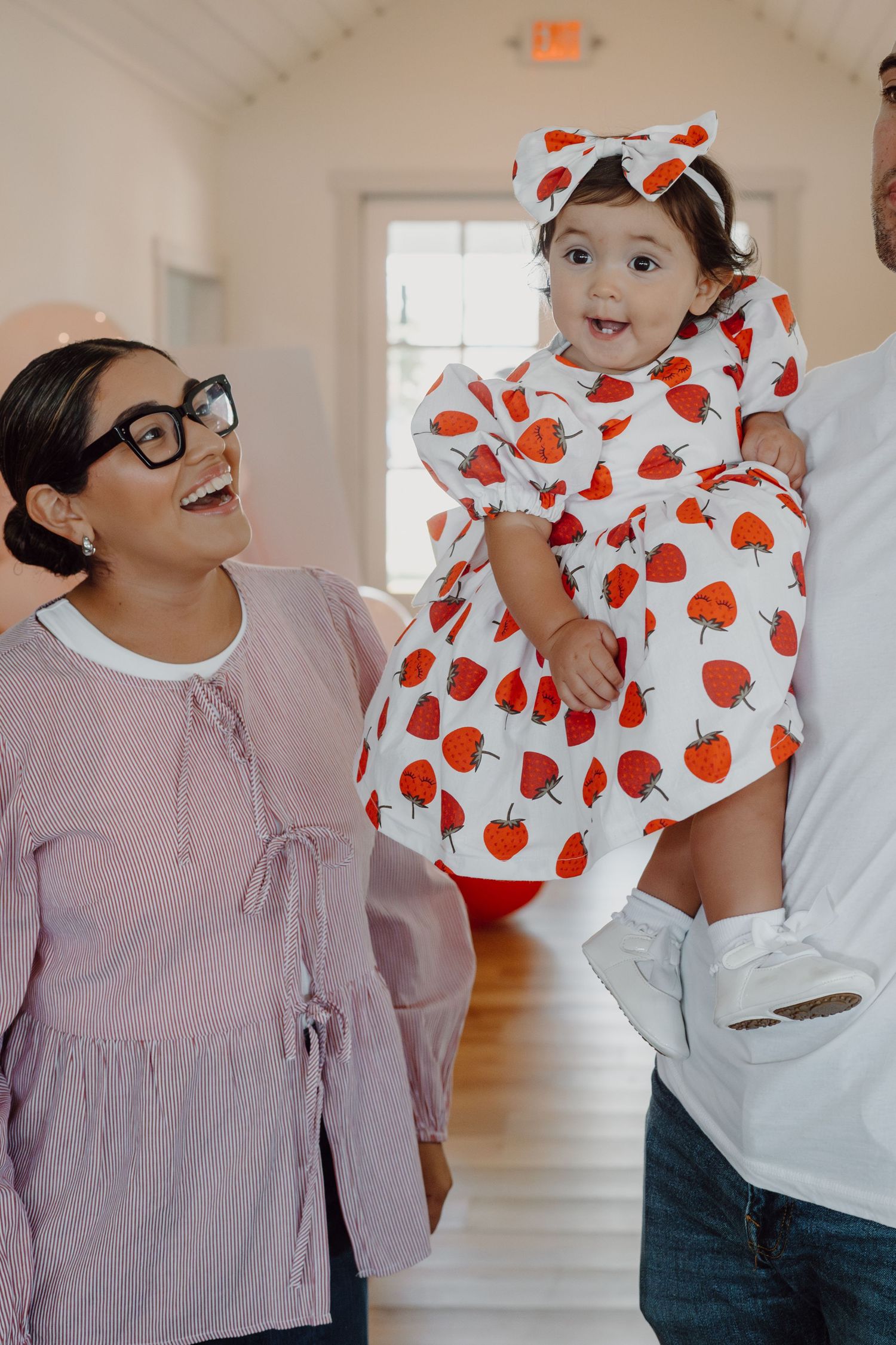 Indoor photoshoot showing coordinated outfits in pink and white with polka dot patterns.