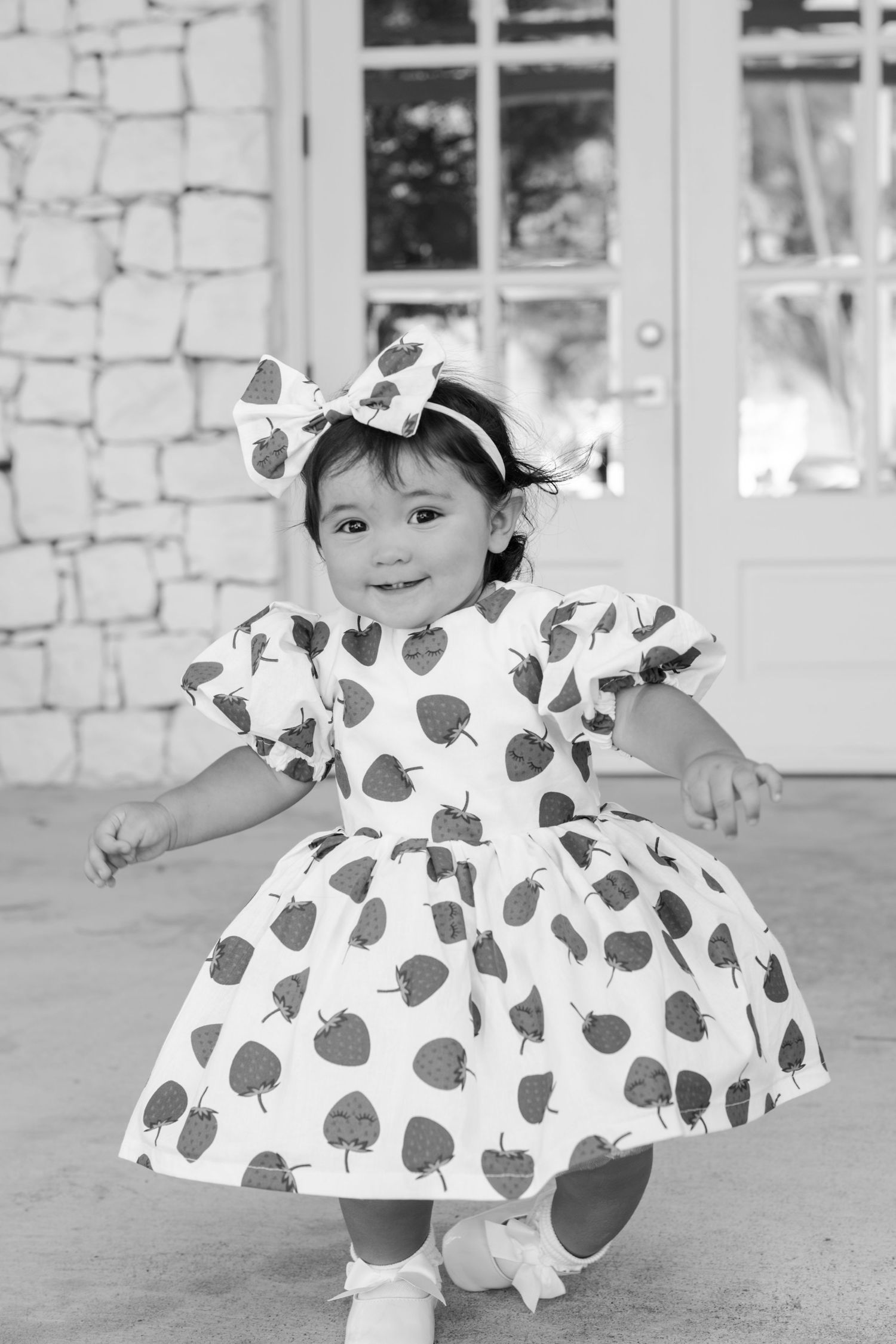 Black and white photo of heart-patterned dress against stone wall backdrop.