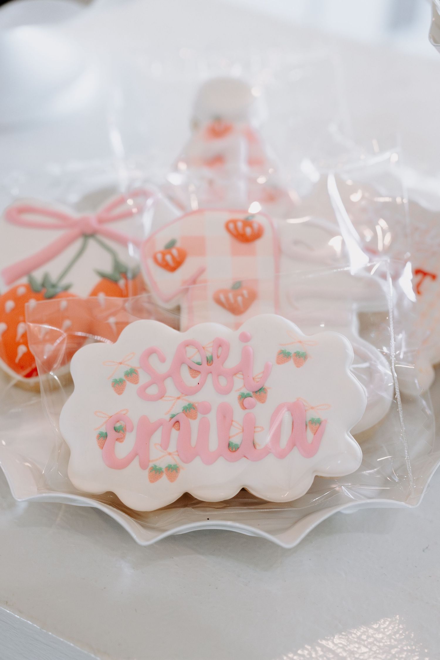 Delicate pink party favor bags with strawberry designs wrapped in clear cellophane.