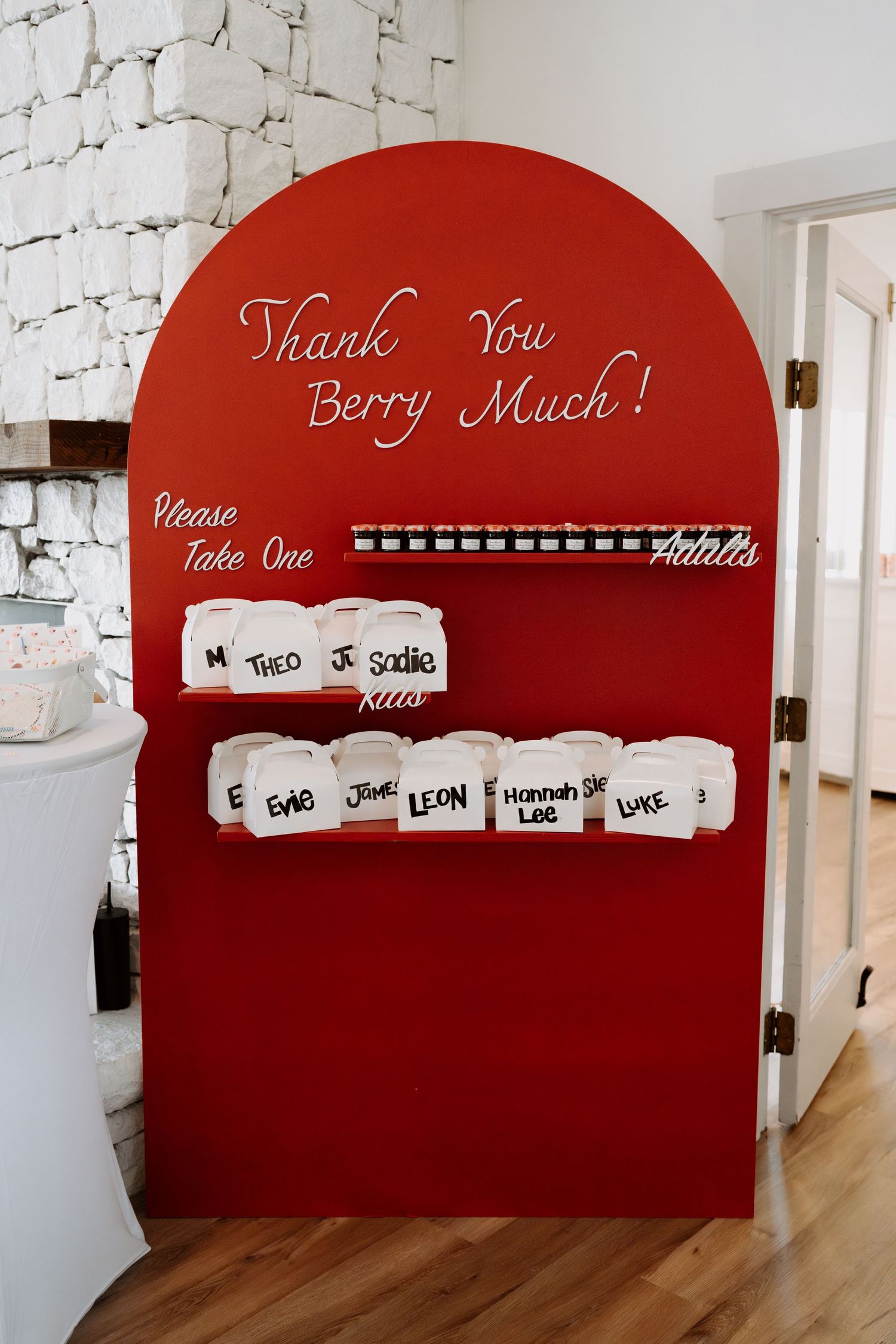 Red curved wall display with white text and small boxes mounted in a line.