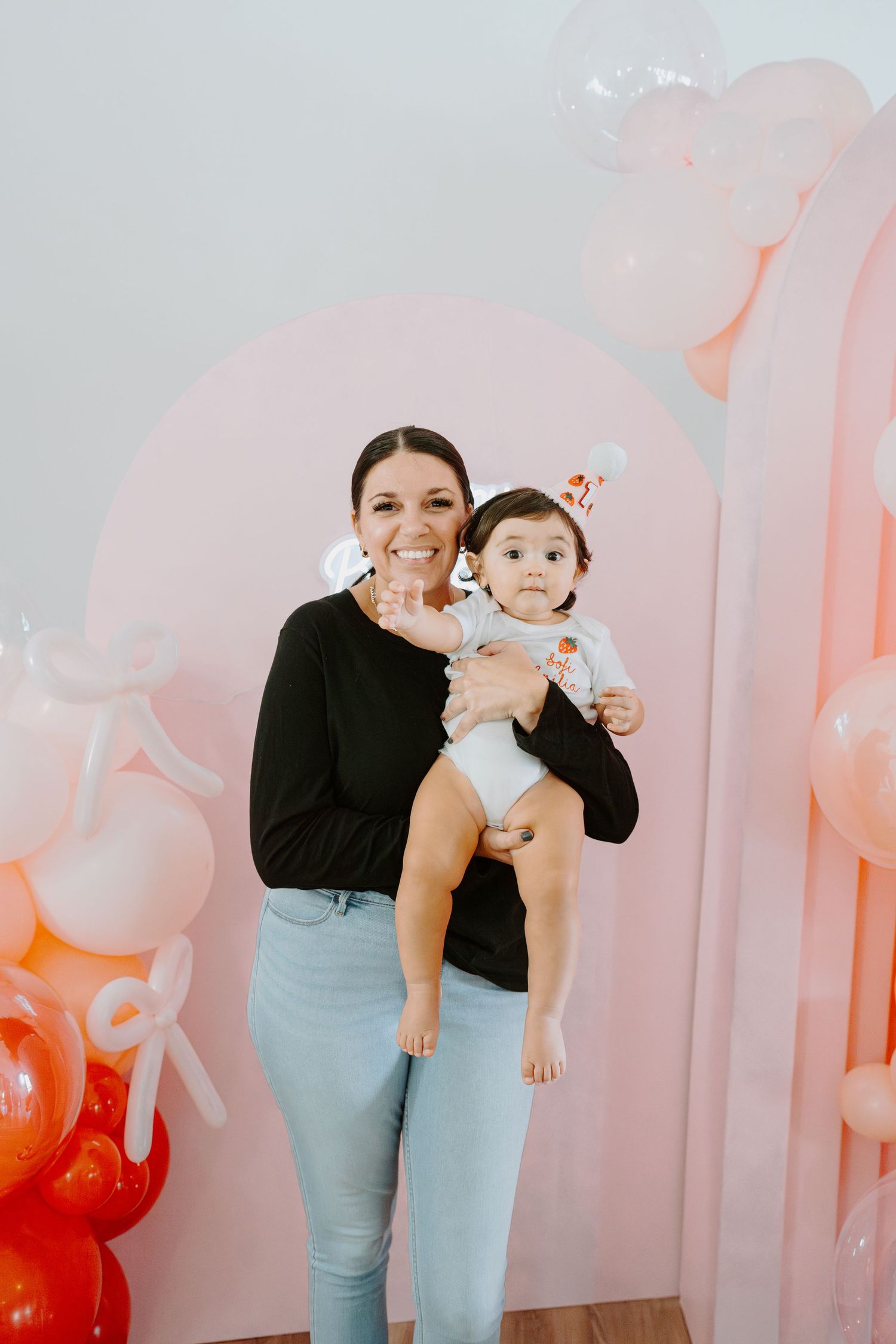 A series of playful poses against a backdrop of peach-colored balloons in a bright interior.