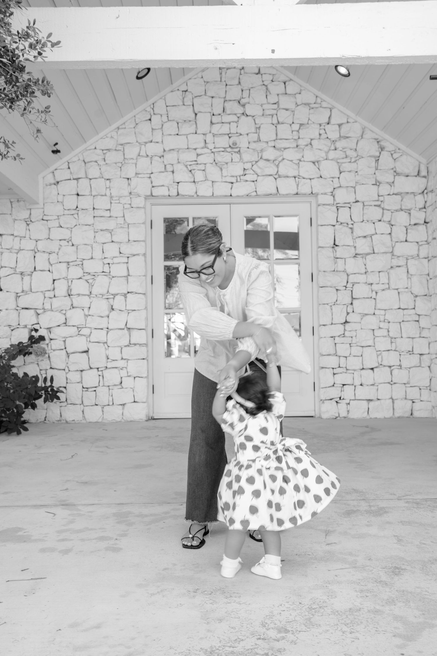 Black and white dance sequence showing spinning motion against stone wall backdrop.