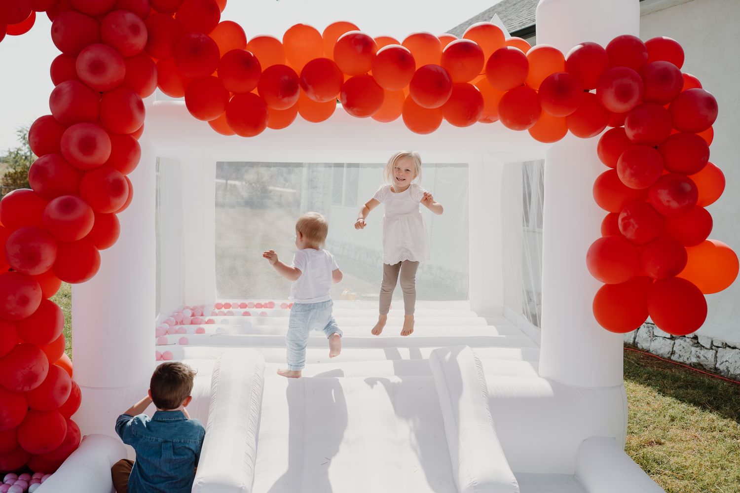 Festive party setup with bright red balloon arches creating a dramatic ceiling display.
