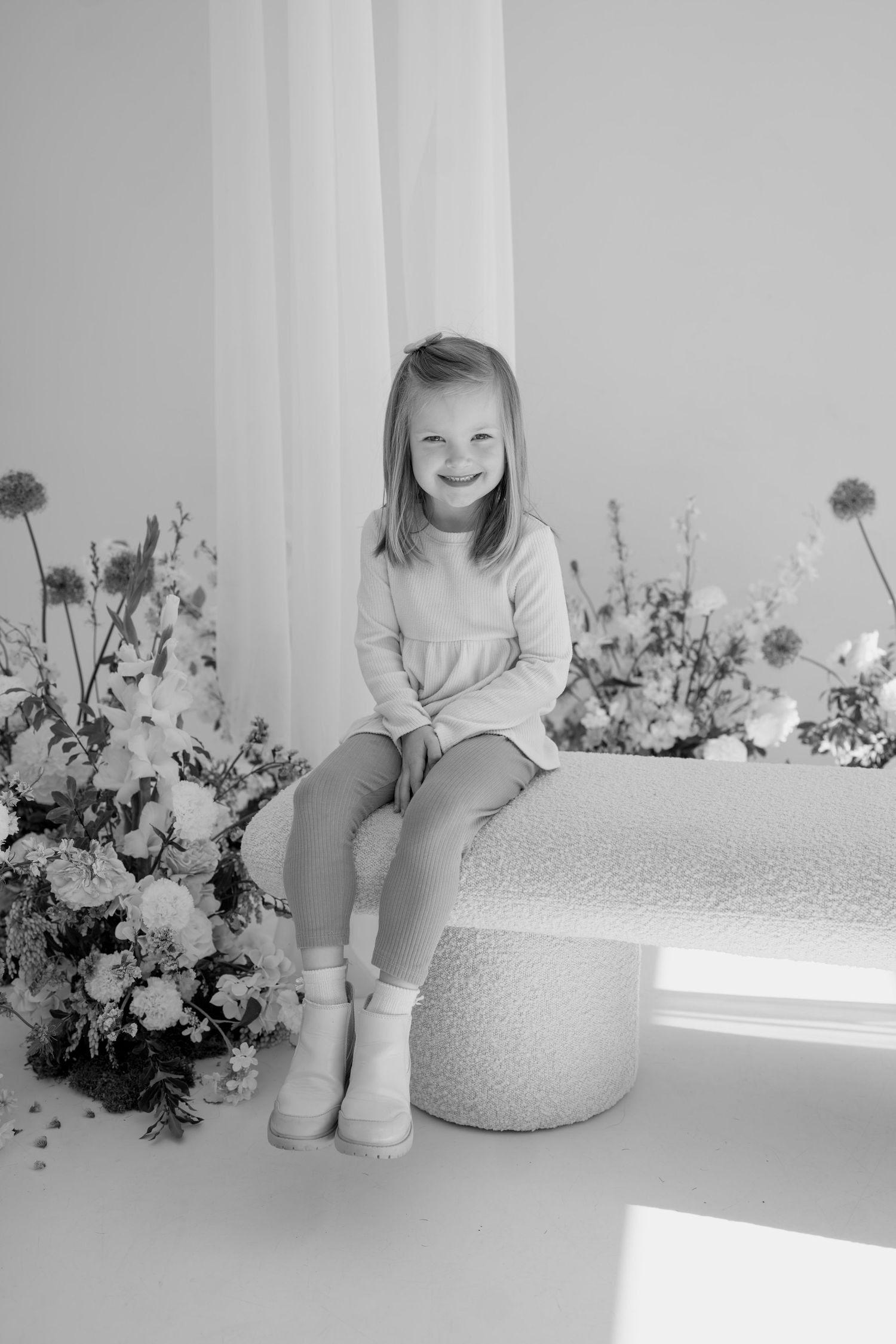 Black and white portrait with elegant floral styling and natural window light.
