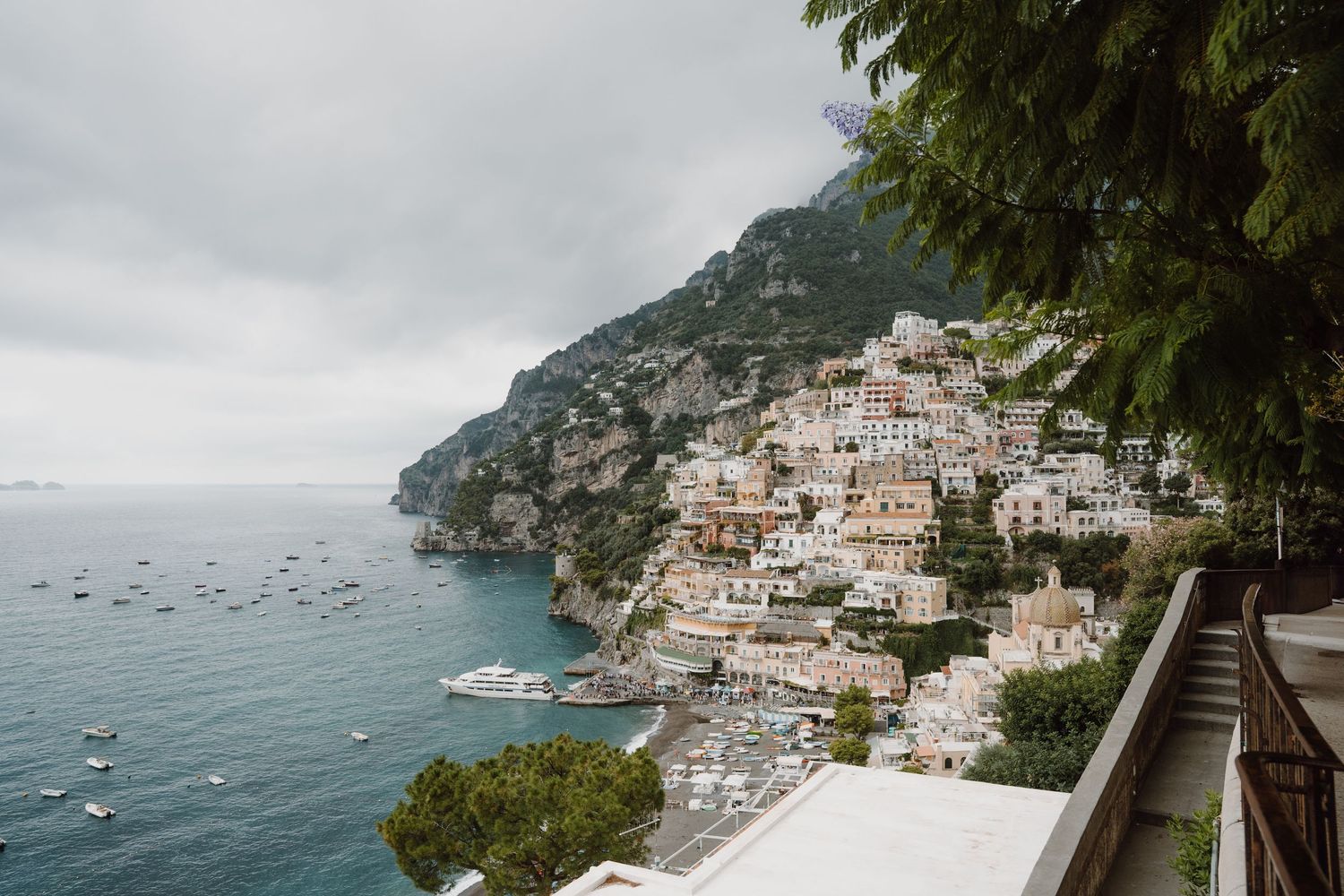 Stunning coastal view of Positano, Italy with colorful buildings cascading down the cliffside to the Mediterranean Sea.