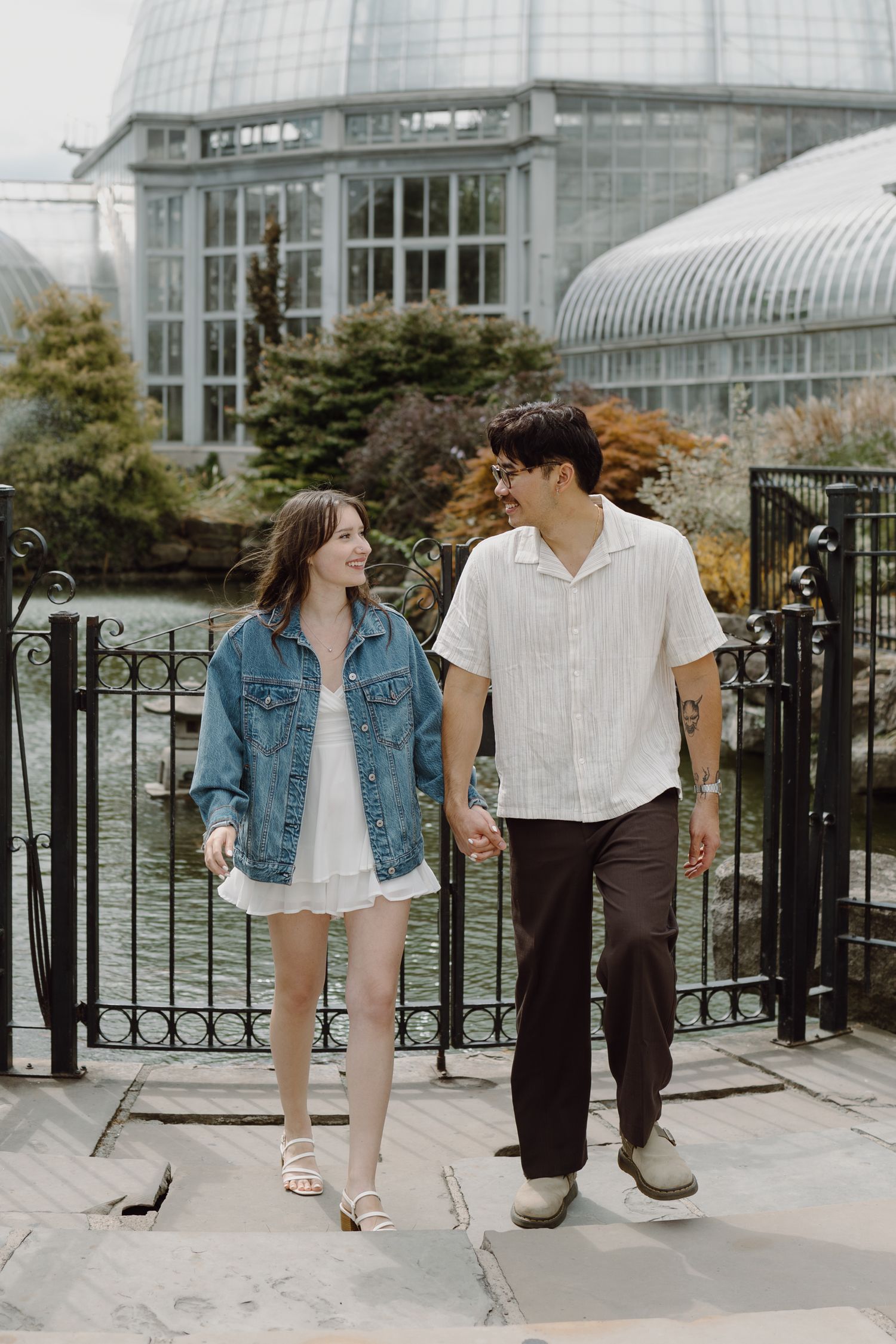 Couple sharing a moment while standing on stone path near conservatory entrance.