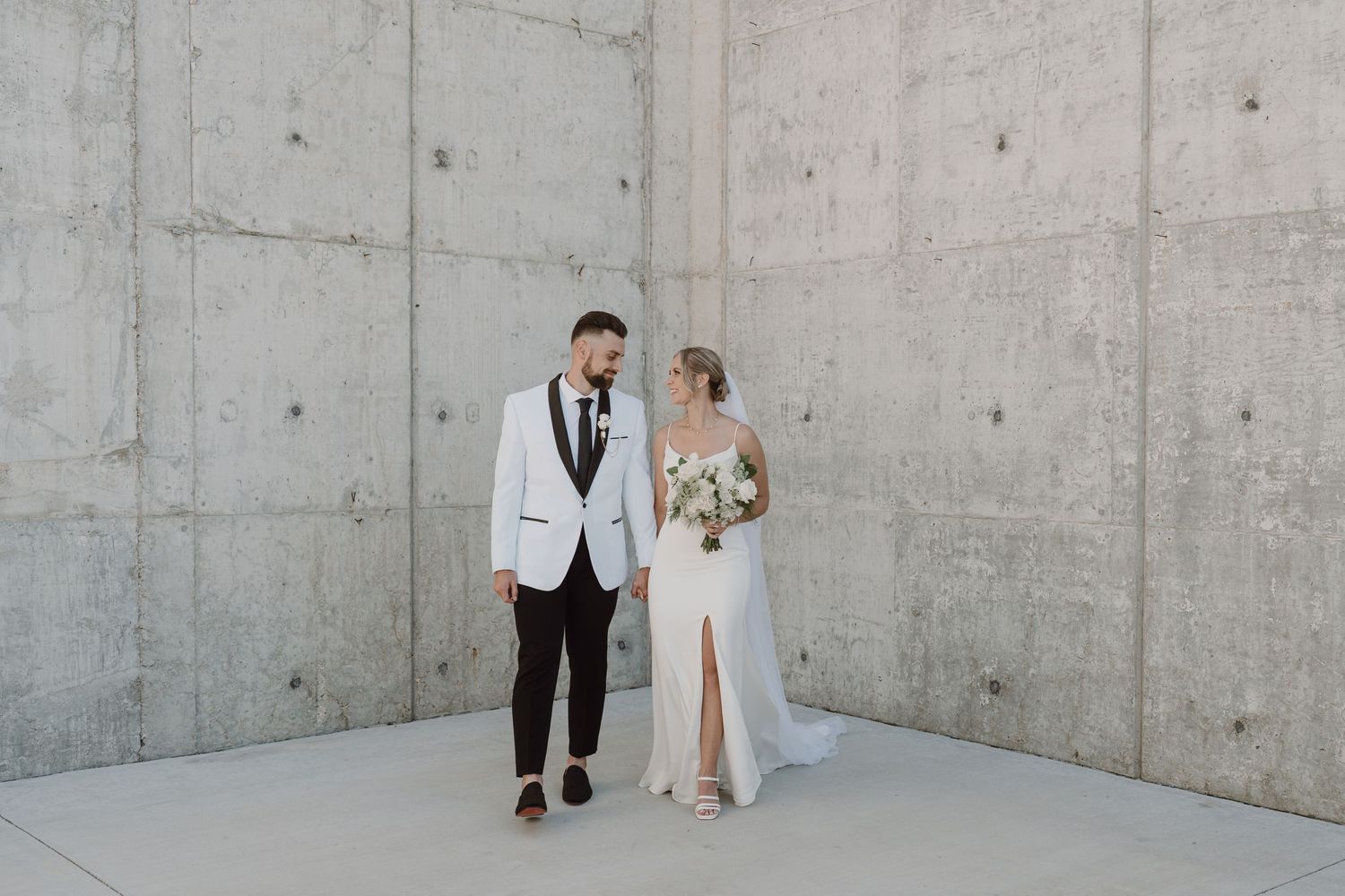 Modern minimalist wedding venue with concrete walls and bright natural lighting.
