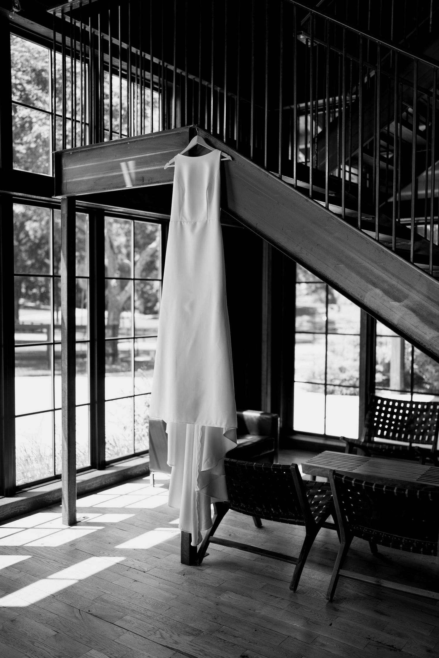 Sunlit interior space with large windows casting dramatic shadows on wooden floors and modern furnishings.