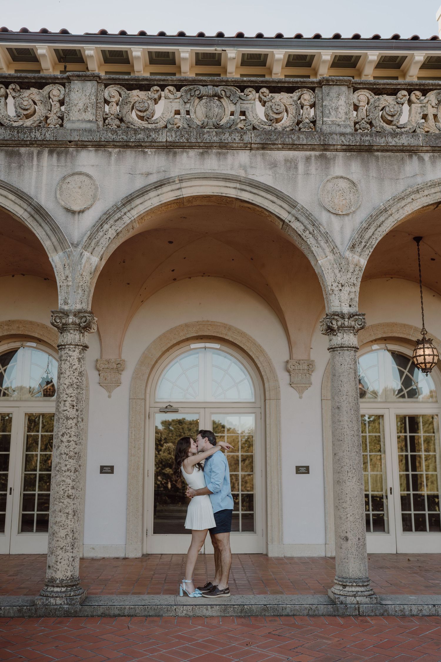 Sequence of romantic moments under decorative archways at an elegant historic venue.