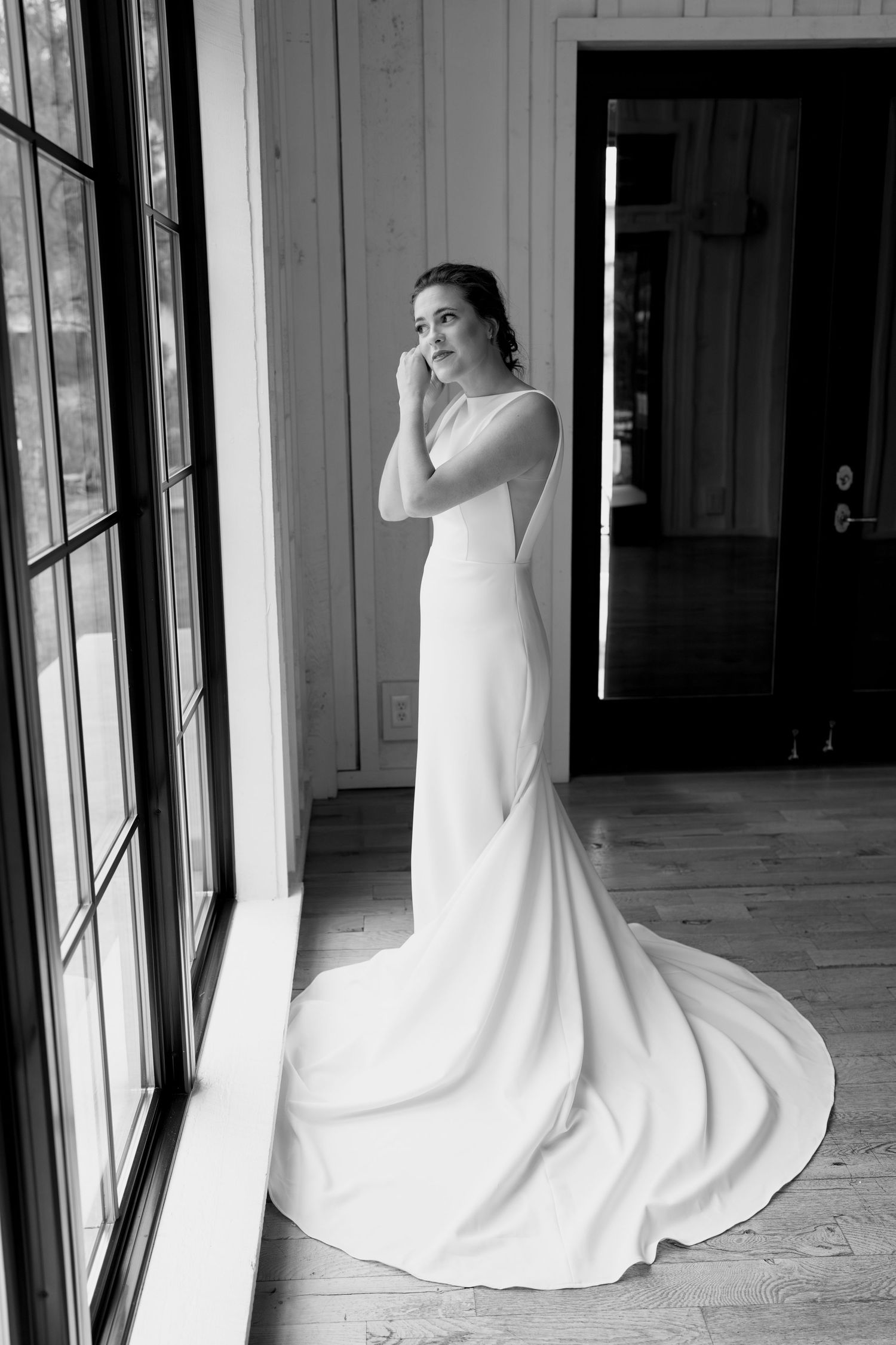 Black and white bridal portrait showing the elegant silhouette of a wedding dress.