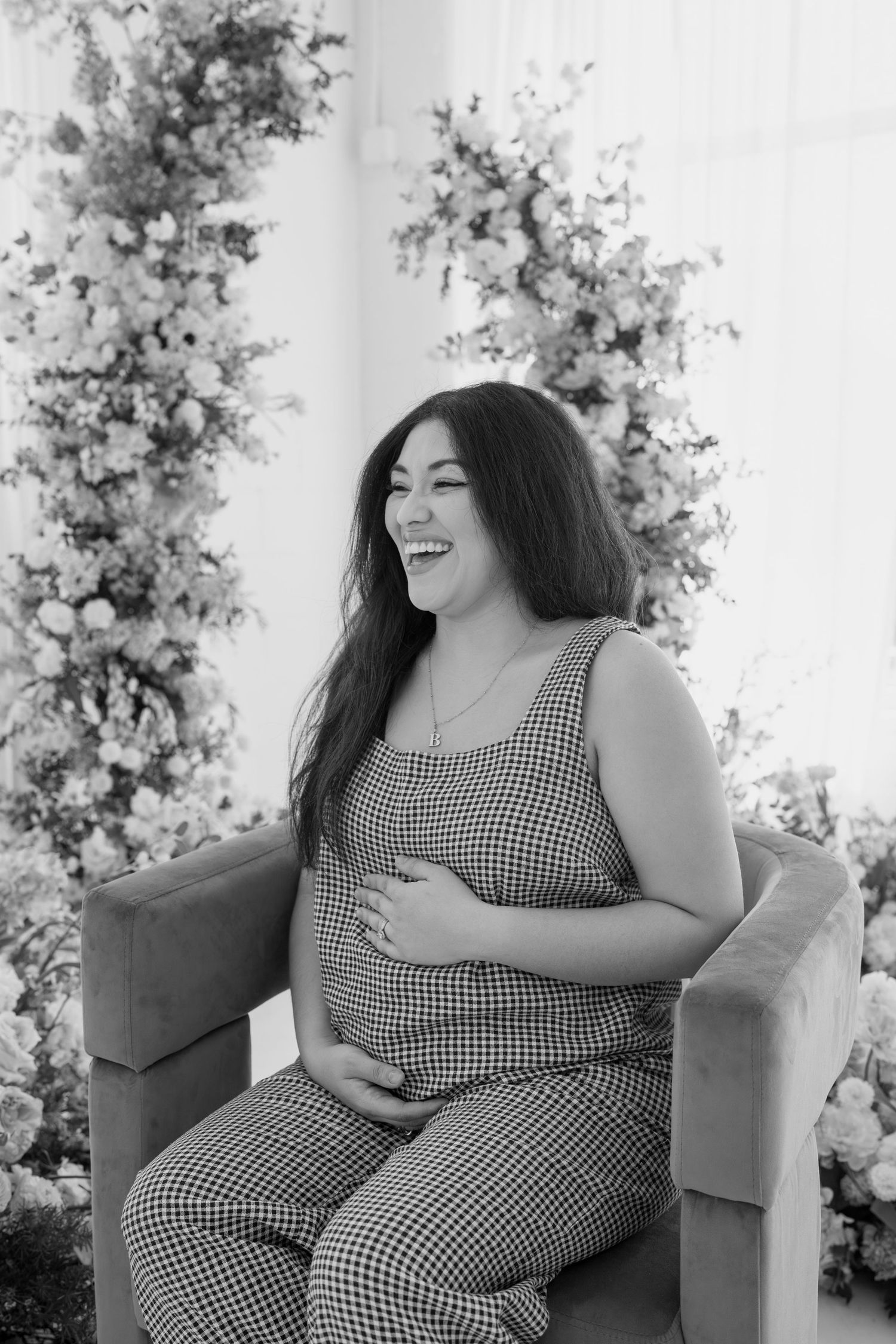 Black and white candid maternity photo showing joyful expression.