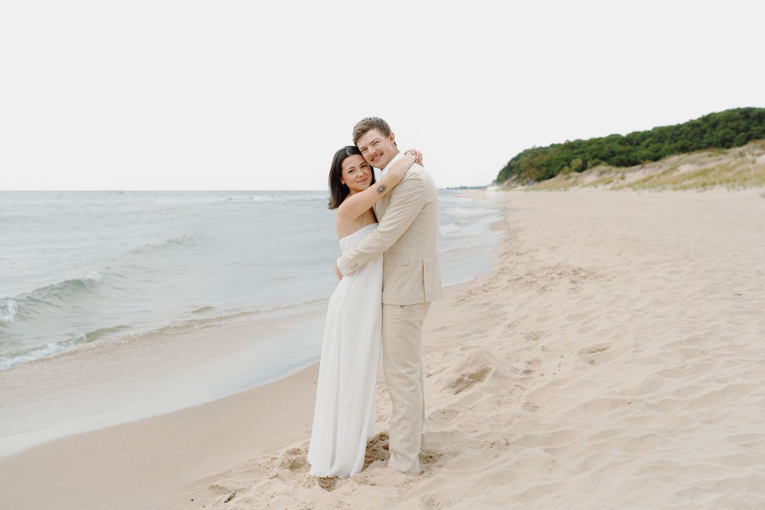 Romantic beach photoshoot featuring couple against coastal landscape.