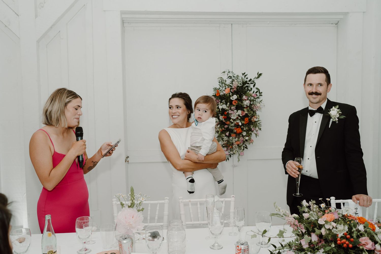 Wedding reception guests enjoying celebrations in an elegant white venue.