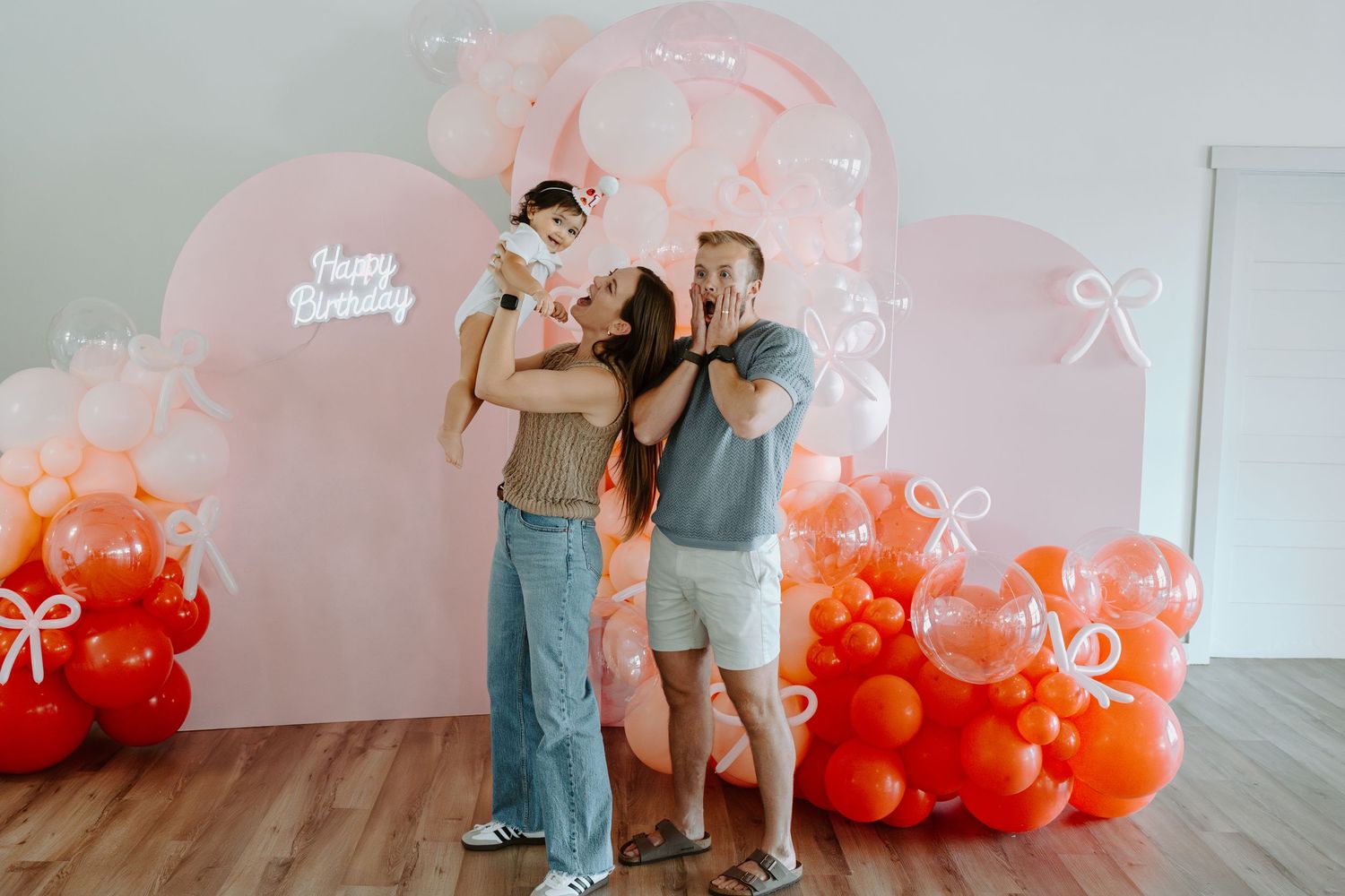 Studio photoshoot featuring a beautiful balloon arch in coral and pink colors.