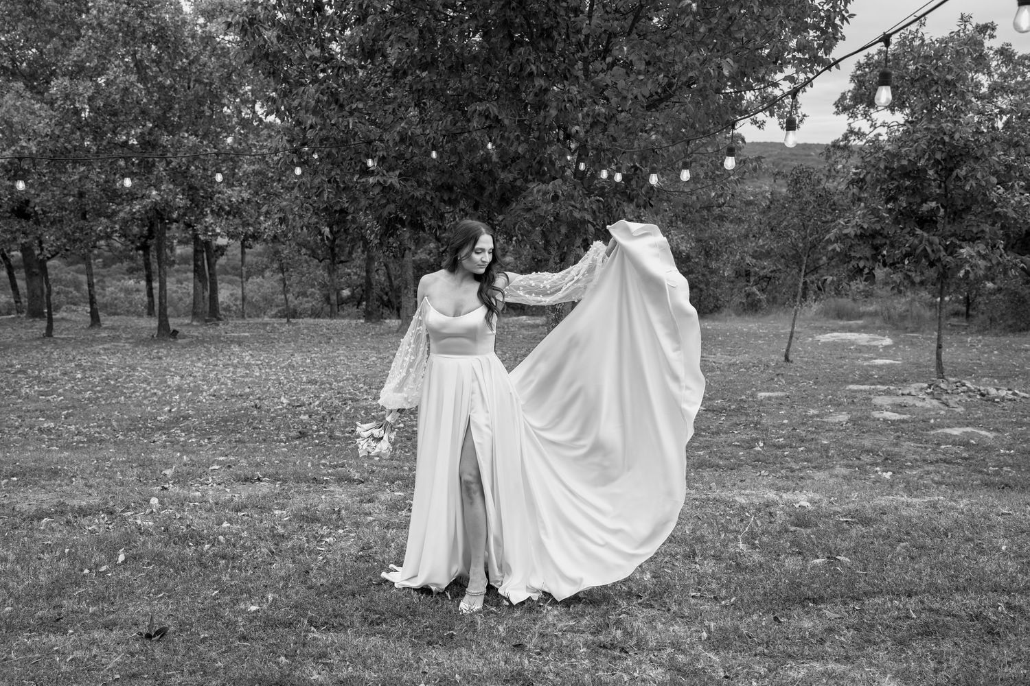 Black and white photo of flowing white wedding dresses in an outdoor autumn setting.