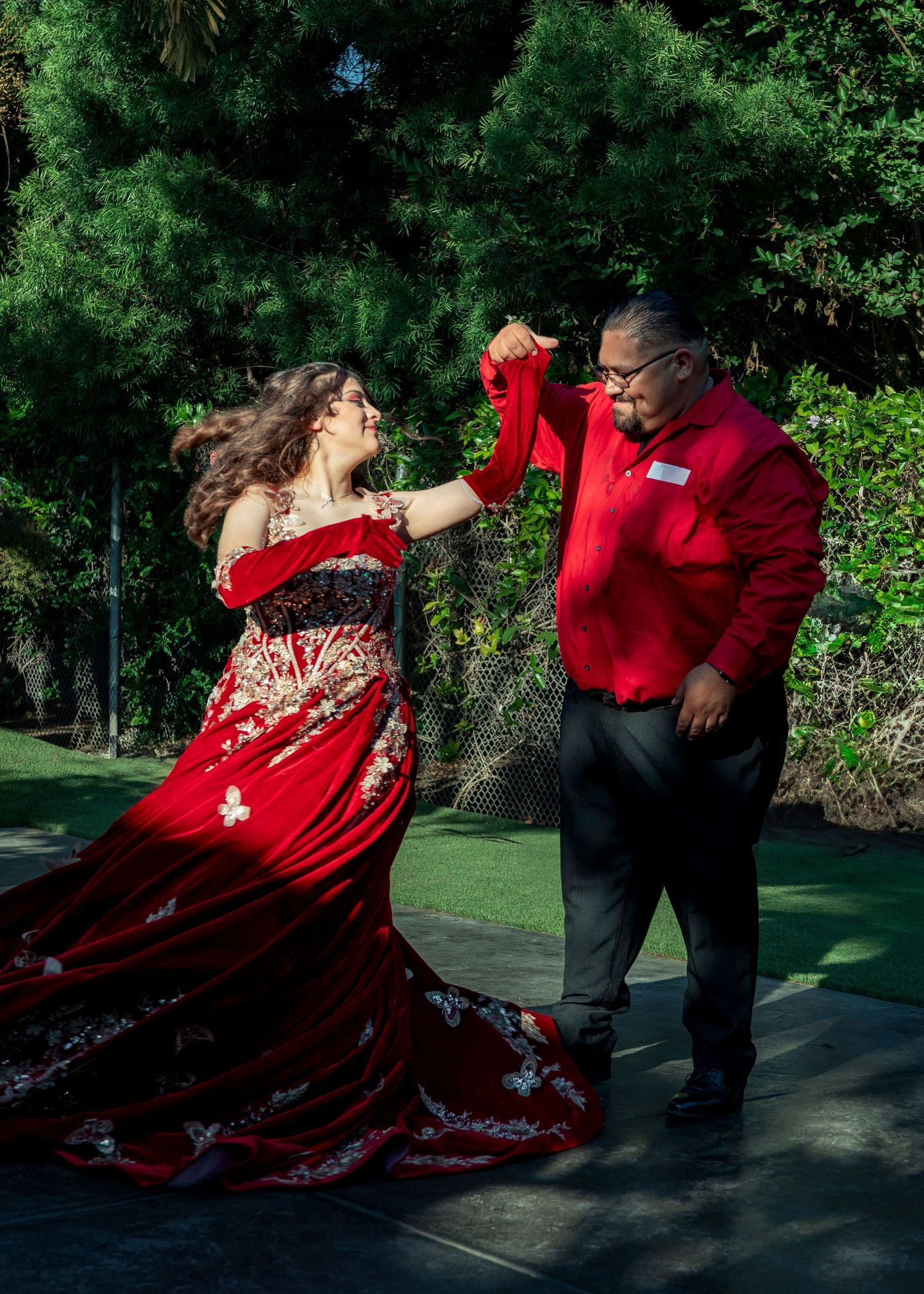 A dramatic dance sequence in a garden setting featuring a flowing red dress.
