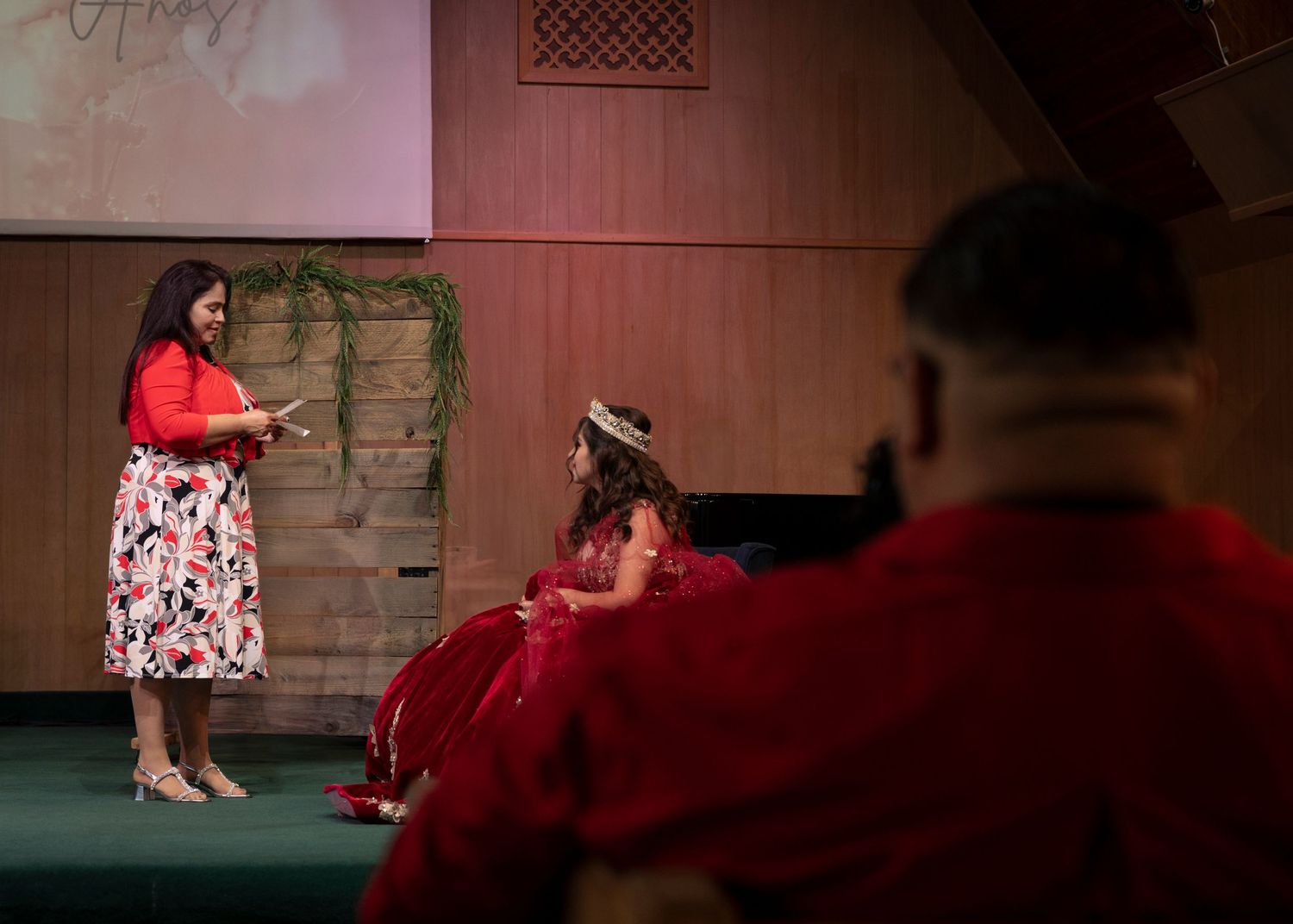 Dark indoor venue with dramatic red lighting and seating arrangements.