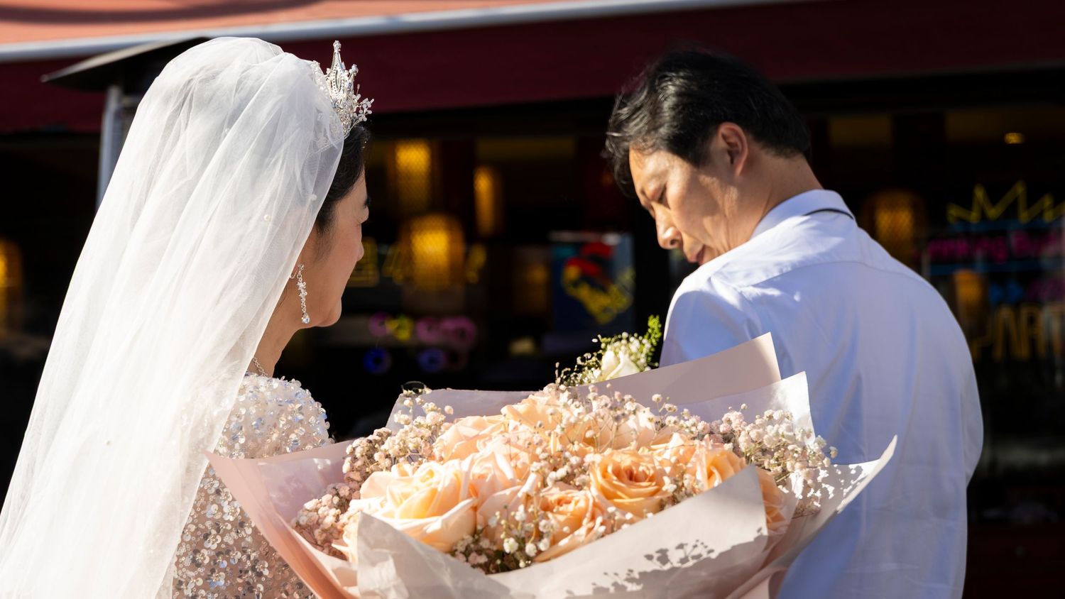 Celebratory gathering at sunset with floral bouquets and decorations.