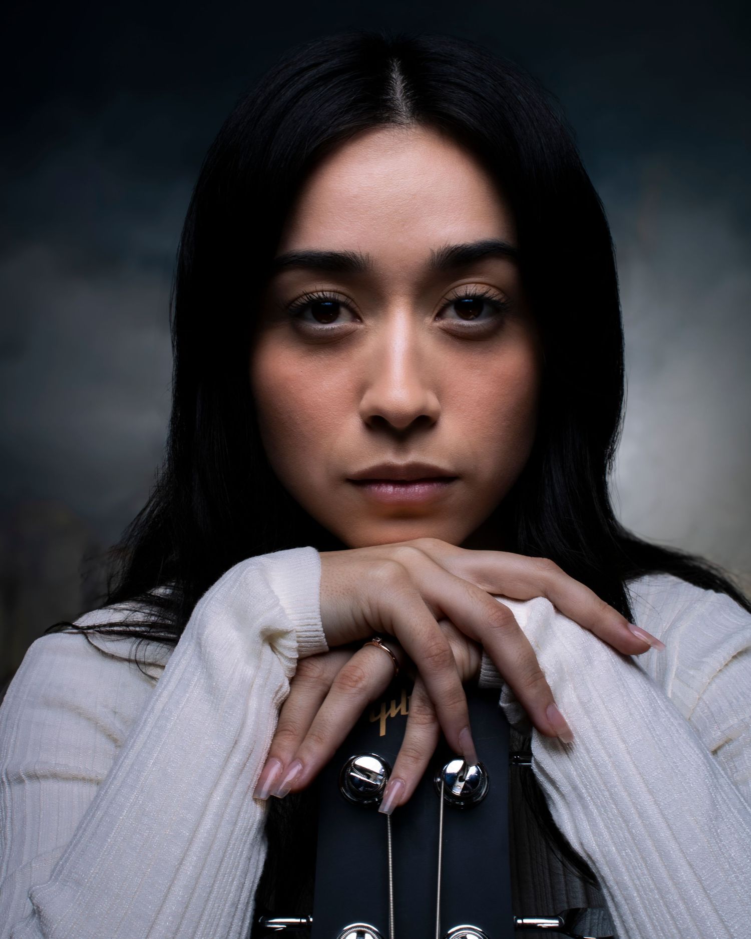 Portrait series showing person in white sweater against dark background.